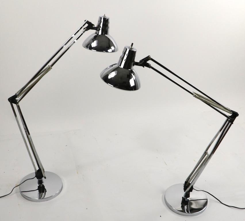 Sophisticated architectural design angle poise lamps in bright chrome finish, in very clean, original and working condition. The lamps swivel, the arms flex and the hood shade tilts and rotates to position and direct the light. Lamps accepts