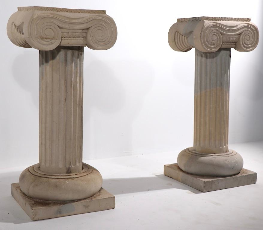 Superbe paire de piédestaux en calcaire sculpté en forme de colonnes classiques cannelées avec des chapiteaux ioniques. Tous deux sont en très bon état d'origine et ne présentent qu'une légère usure cosmétique, normale et conforme à l'âge. Les