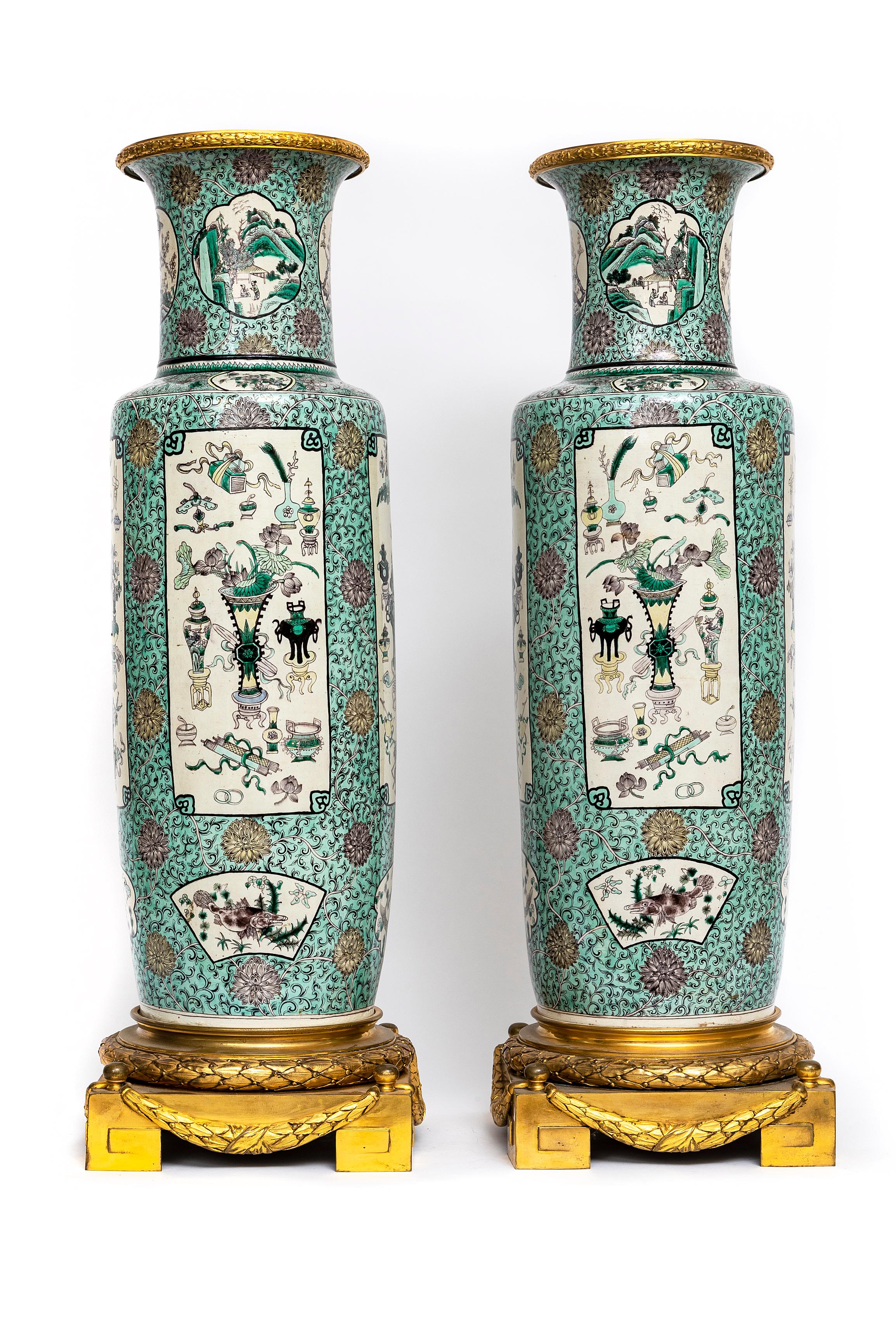 A Magnificent, Rare, and Large Pair of Chinese Kangxi (18th Century) Famille Vert Porcelain French Louis XVI Style (19th Century) Ormolu Mounted Solider Vases.  These monumental vases are intricately enameled in sea foam, forest green, beige, black,