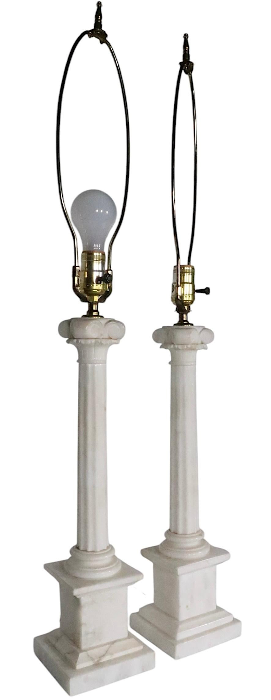 Chic pair of marble column form table lamps, in very good, clean, working condition. The lamps feature a stepped plinth base with a  fluted column center post, and scrolled capitol. The lamps retain an Underwriters Laboratories Inc. Wilmar Co. Inc. 