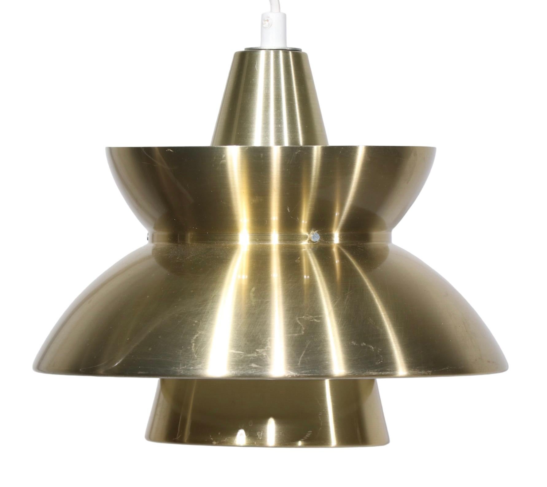Nice pair of Doo Wop style Jorn Utzon Sovaernspendel  tiered pendant fixtures, made in Denmark c. 1960's. The chandeliers have light weight aluminum bodies, which are in original anodized brass finish - showing light cosmetic wear, normal and