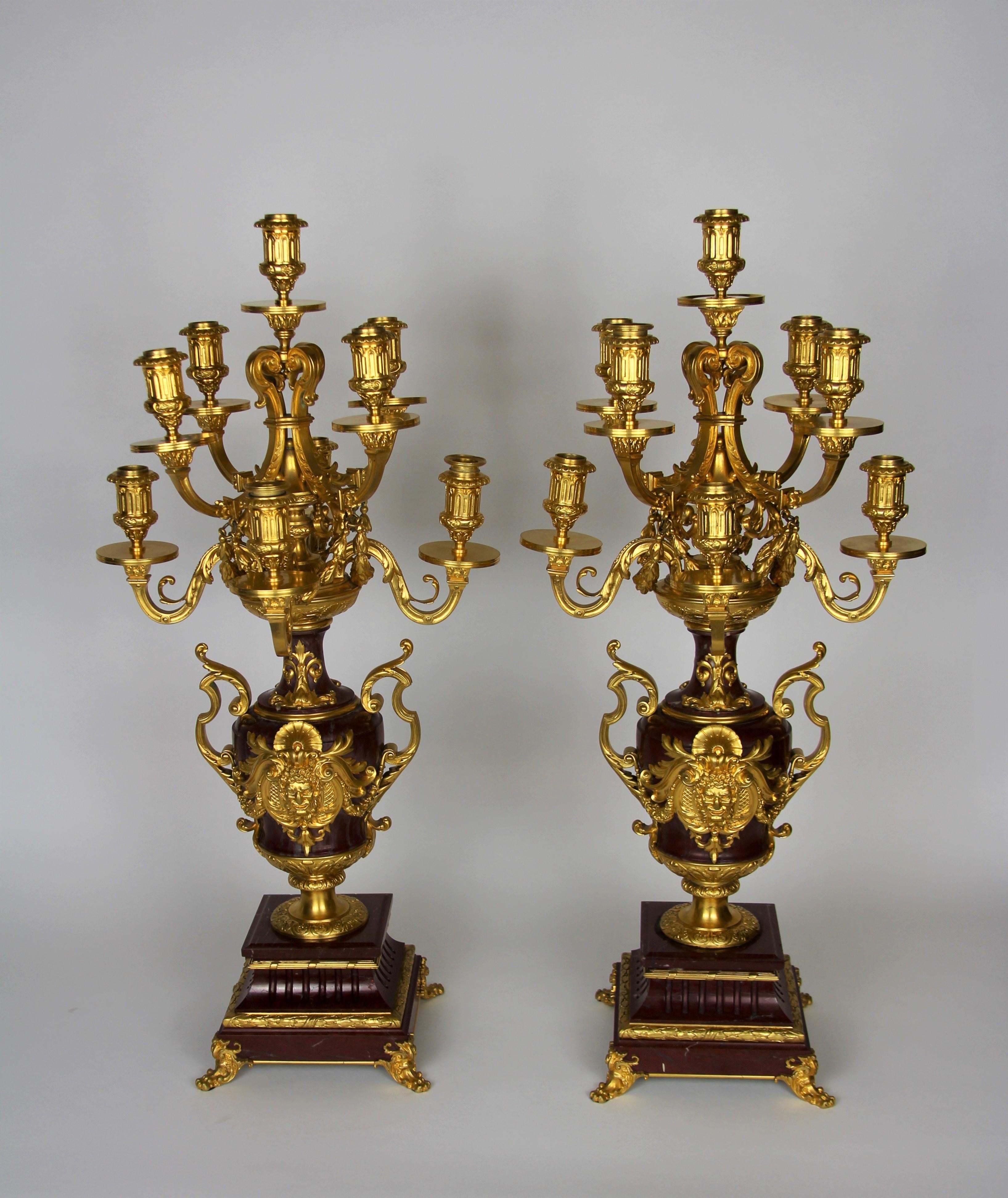 A fantastic pair of Louis XVI style doré bronze mounted rouge marble 9-arm candelabras with doré Bronze Hercules Masks and doré bronze swirling S-style handles, signed Barbedienne. This is truly a marvelous pair of candelabras made with the finest