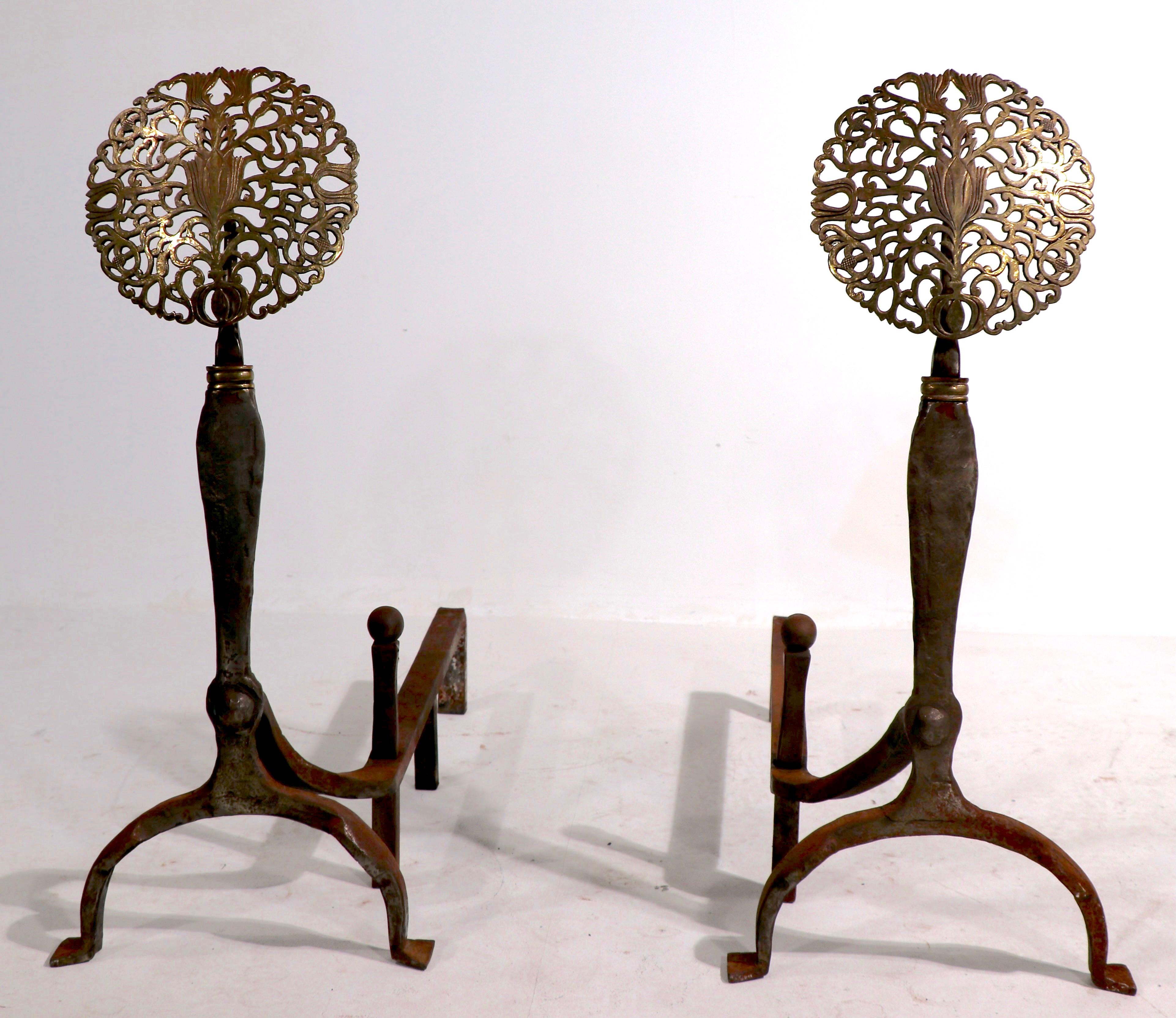 Impressive pair of English Arts & Crafts andirons, having brass foliate tops, on hand wrought iron bases. The andirons are in very Fine, original condition, clean and ready to use. 
 Dia. of foliate top 8.5 inch.