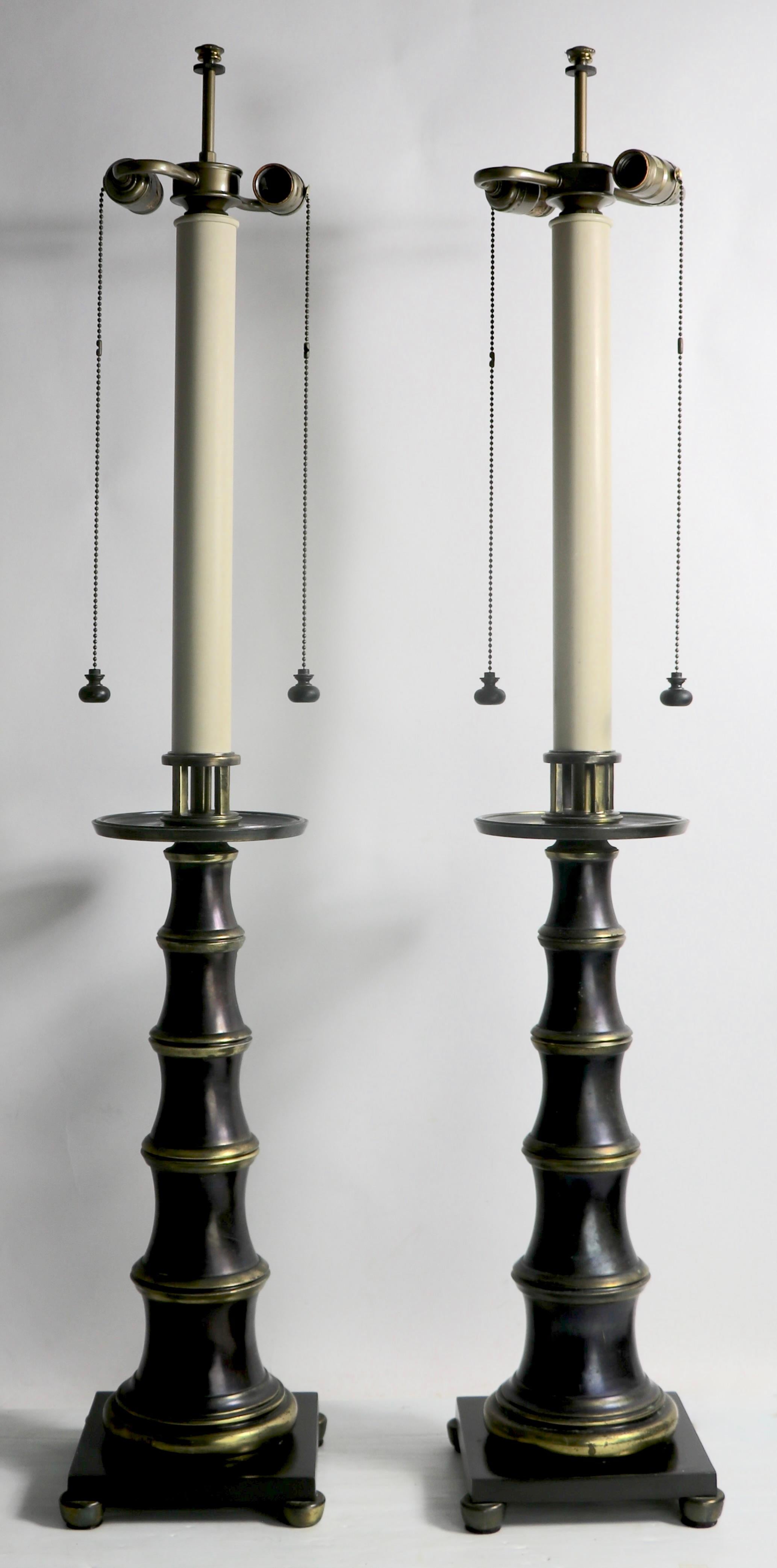 Stately  and impressive pair of faux bamboo, Hollywood regency, Campaign style table lamps by the noted American manufacturer, Stiffel. The lamps are in very good, original, clean and cooking condition, each taking two standard size screw in bulbs -
