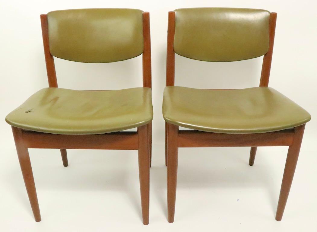 Architectural pair of teak and leather dining chairs designed by Finn Juhl for France and Son, model 197, circa 1960s.
Both chairs are structurally sound and sturdy, both show wear to upholstery, please see images.
Offered and priced as a pair,