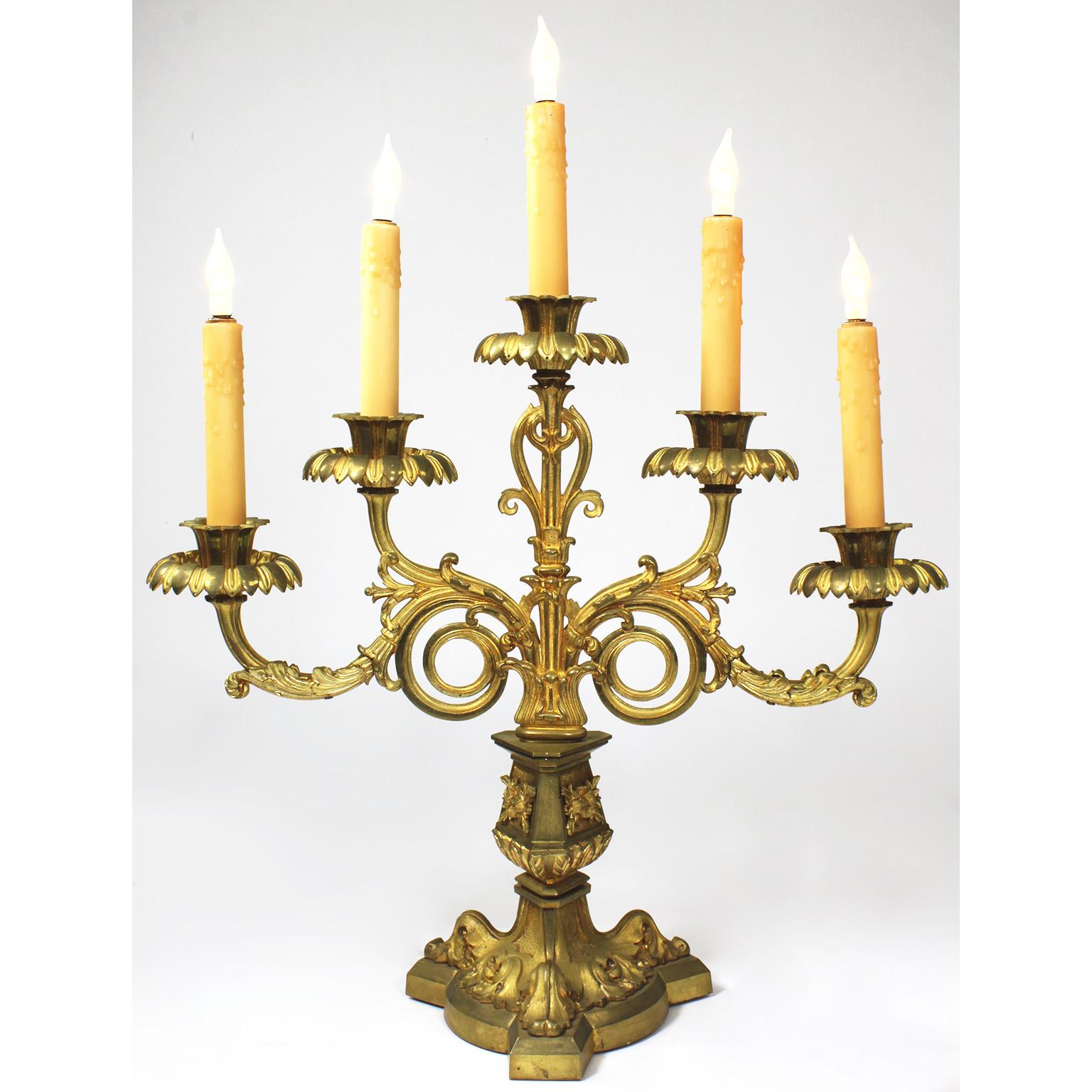 A fine pair of French 19th century Gothic-Revival neoclassical style five-light gilt-bronze candelabra. The finely chased gilt-bronze tripod-leaf base, surmounted with floral rosettes supporting five scrolled candelabrum arms. (Now electrified).
