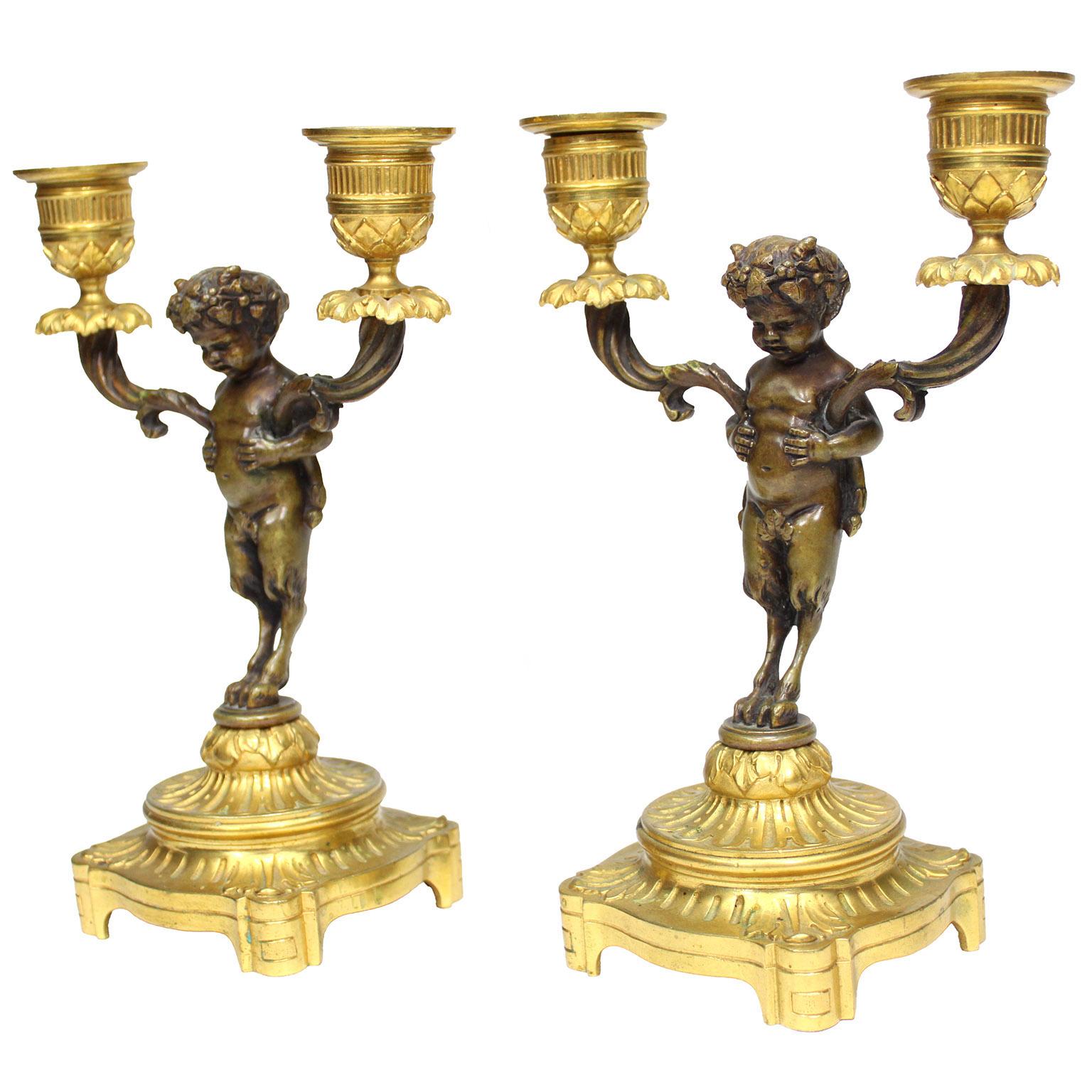 Fina pareja de candelabros de dos luces de estilo Luis XV francés del siglo XIX, patinados y dorados, según Claude Michel Clodion (francés, 1738-1814). Cada uno de ellos presenta una figura de pie de bronce patinado de un 