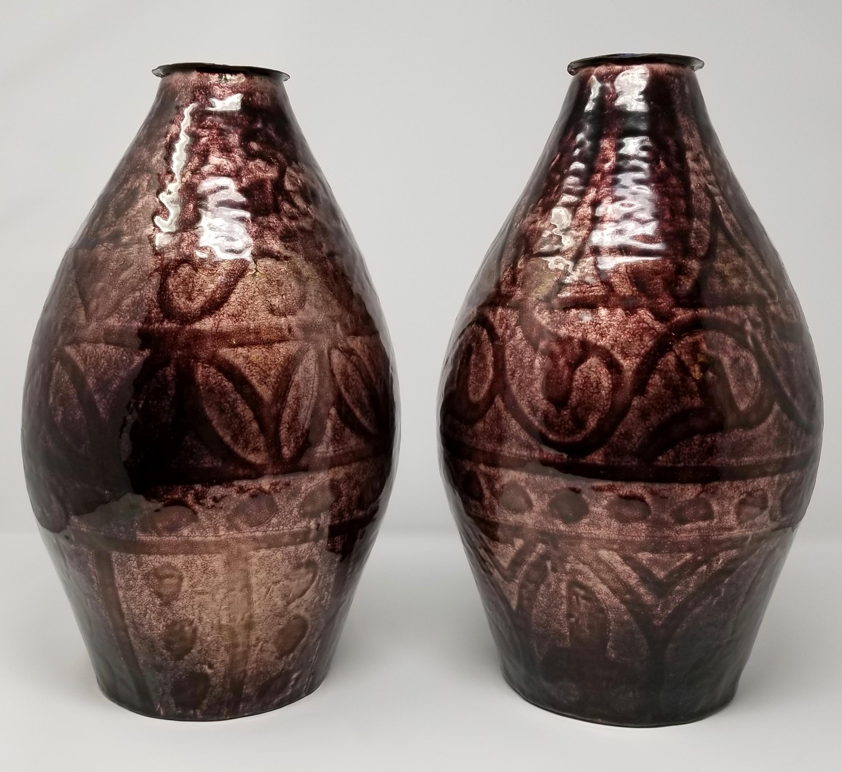 A fabulous pair of large antique French Art Deco period purple enamel on copper vases with Iridescent Geometric designs, attributed to Camille Faure. This beautiful pair of vases have a unique color-way with mixed iridescent purple and red hues and