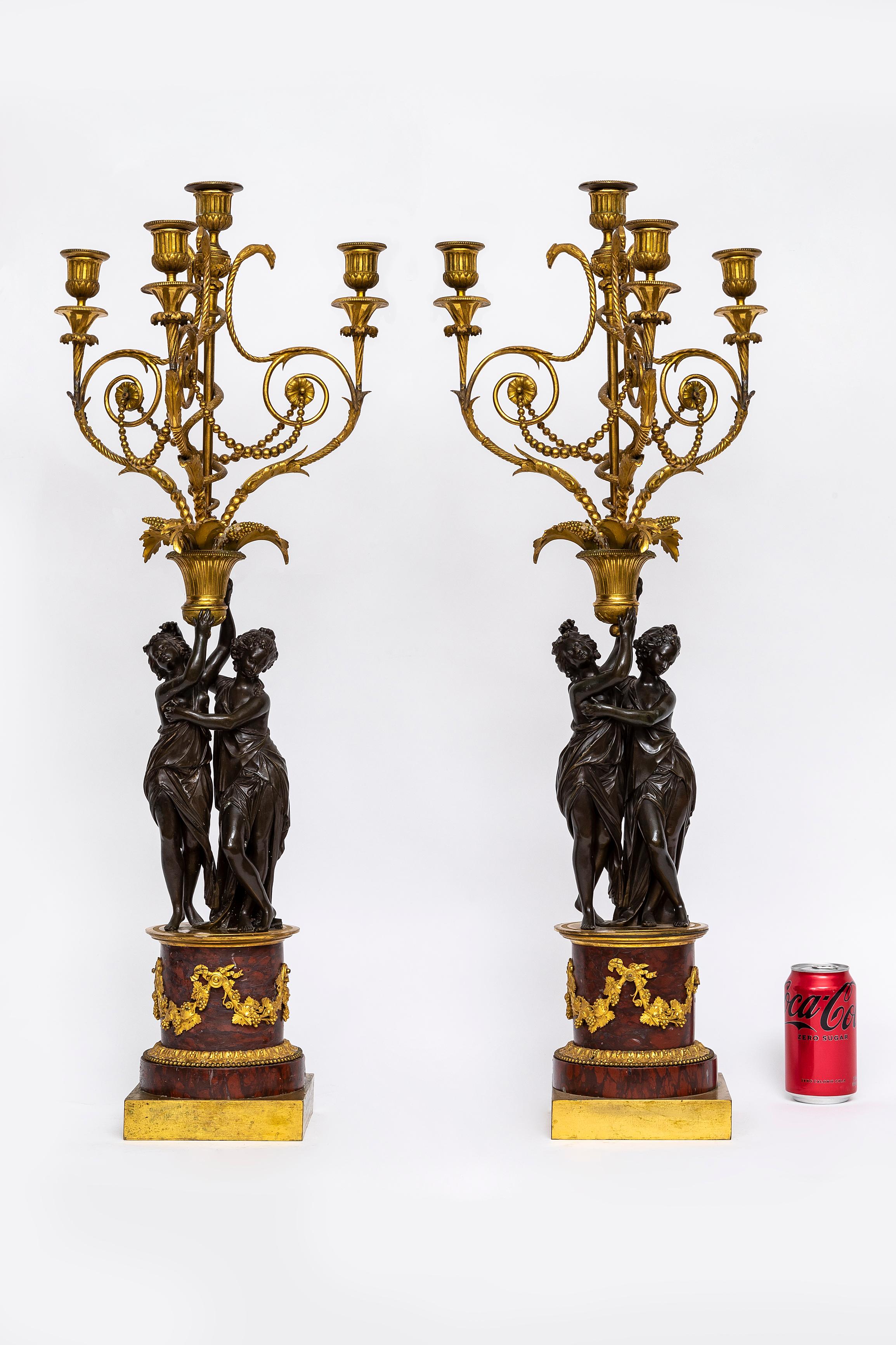 A Large and Quite Rare Pair of French Louis XVI Period Patinated and Dore Bronze Figural Four-Light Candelabra with Ormolu-Mounted Rouge Marble Bases.  Each candelabra features finely cast and chased ormolu elements and mounted on rouge marble