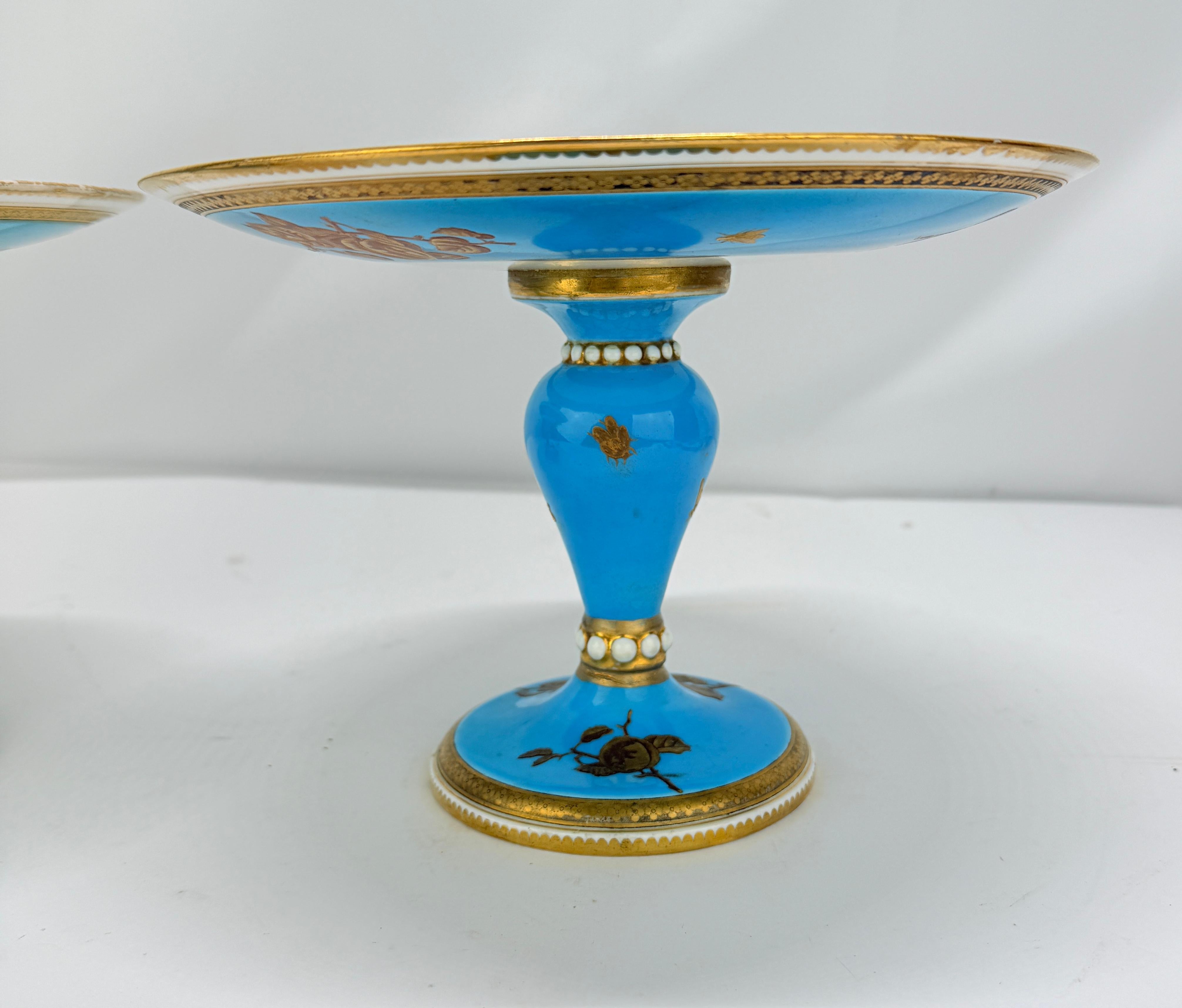 Refinada pareja de compoteras de pedestal de porcelana francesa, probablemente de fabricación parisina o de Limoges, de finales del siglo XIX. Cada uno tiene un plato circular poco profundo elevado sobre un tallo balaustre torneado y un pie circular