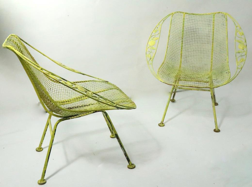 Pair of wrought iron and metal mesh garden, patio, poolside chairs - Chantilly Rose Sculptura, by Woodard, both chairs are in good, vintage condition, both are in later yellow paint finish and both show cosmetic wear normal and consistent with age.