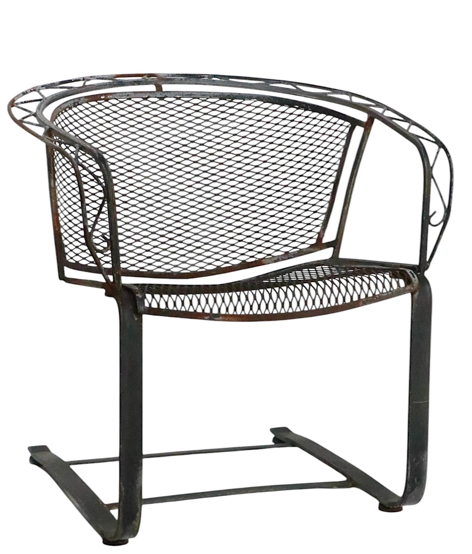 Pair of vintage garden, patio, poolside  wrought iron and metal mesh lounge chairs, by Salterini. The chairs feature a Zig Zag pattern back support, executed in wrought iron, metal mesh seats and backrests, on flat bar  cantilevered legs. Both