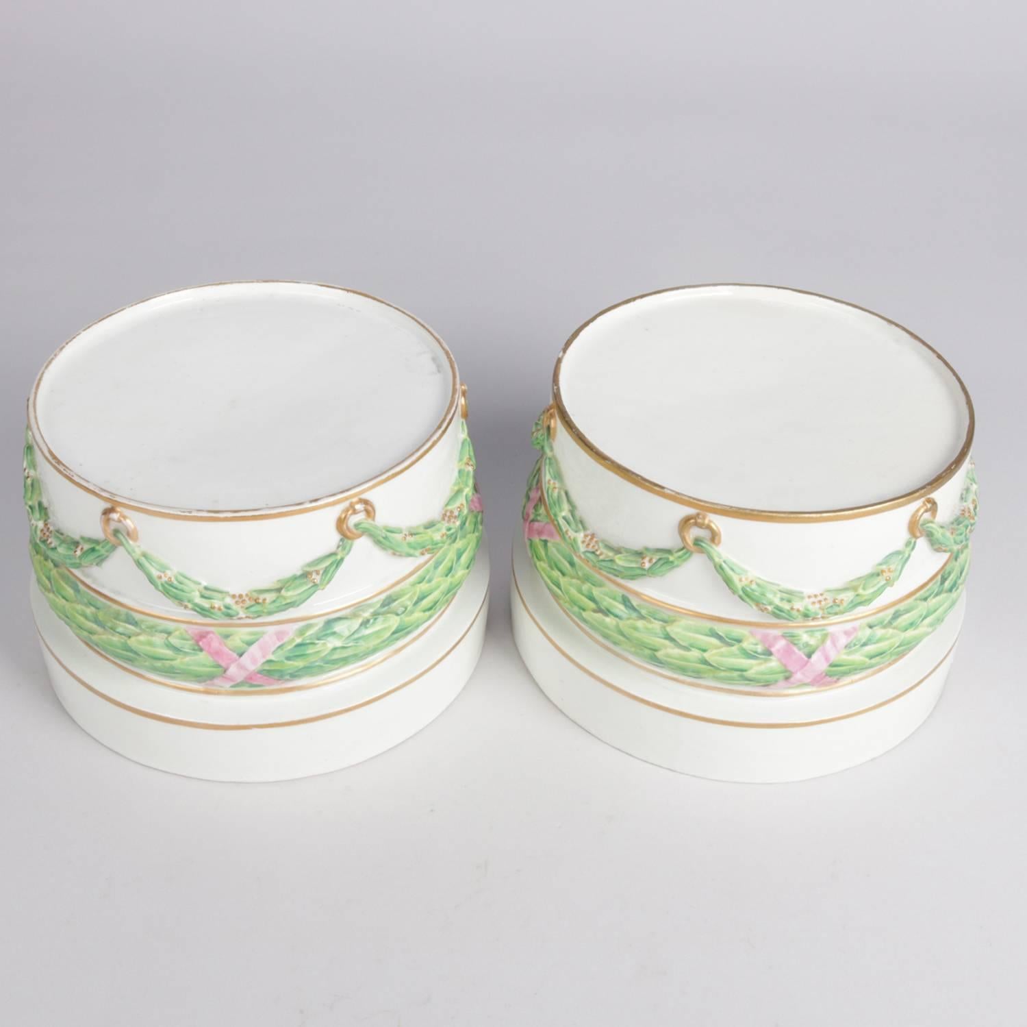Pair of German porcelain round sculpture plinths/bases feature hand-painted and gilt draped garland decoration, en verso blue crossed sword mark and 