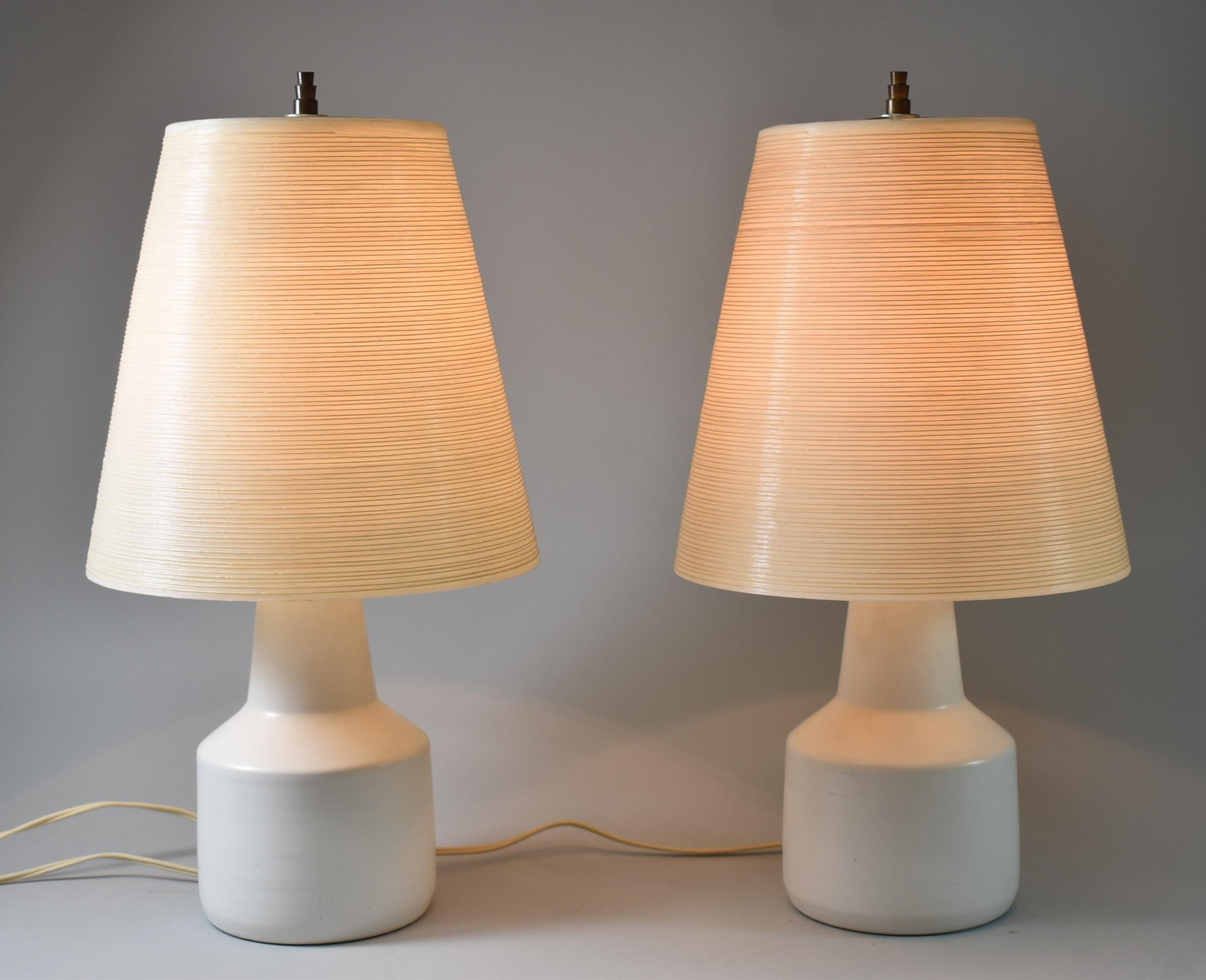 Pair vintage eggshell white pottery lamps by Lotte & Gunnar Bostlund Canada circa 1960's. Original fiberglass and string lamp shades with a skyscraper finial. 18