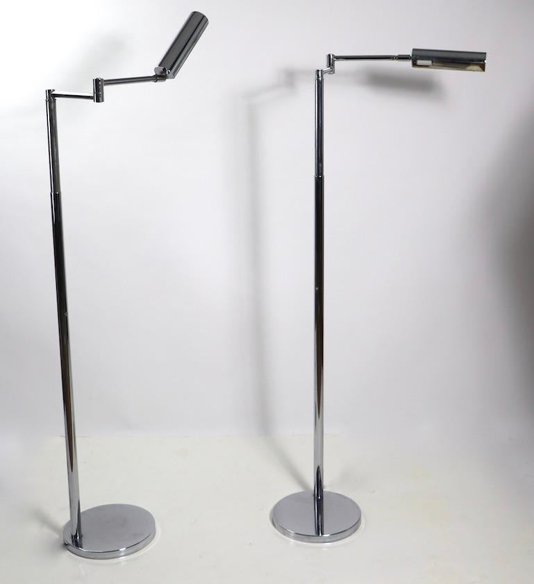 Pair of stunning bright chrome adjustable floor lamps by Koch and Lowy. The lamps feature an adjustable hood shade 8 in. L on flex arms, each 8 in L and a vertical center post which raises from 40 to 50 in. H. base 10 in. diameter both are in very