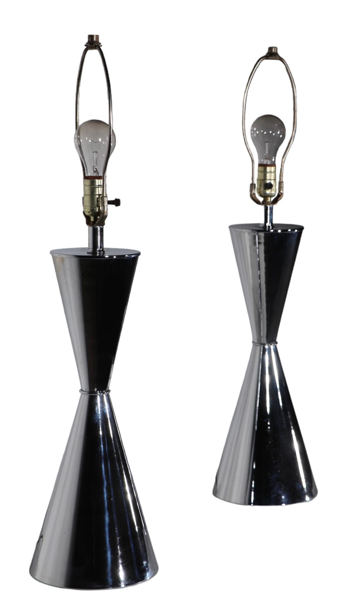 Exceptional pair of 1970's hourglass form chrome table lamps, attributed to Sonneman, in the style of Kovacs. The lamps are in good, original vintage, estate condition, showing light cosmetic wear, normal and consistent with age, specific condition