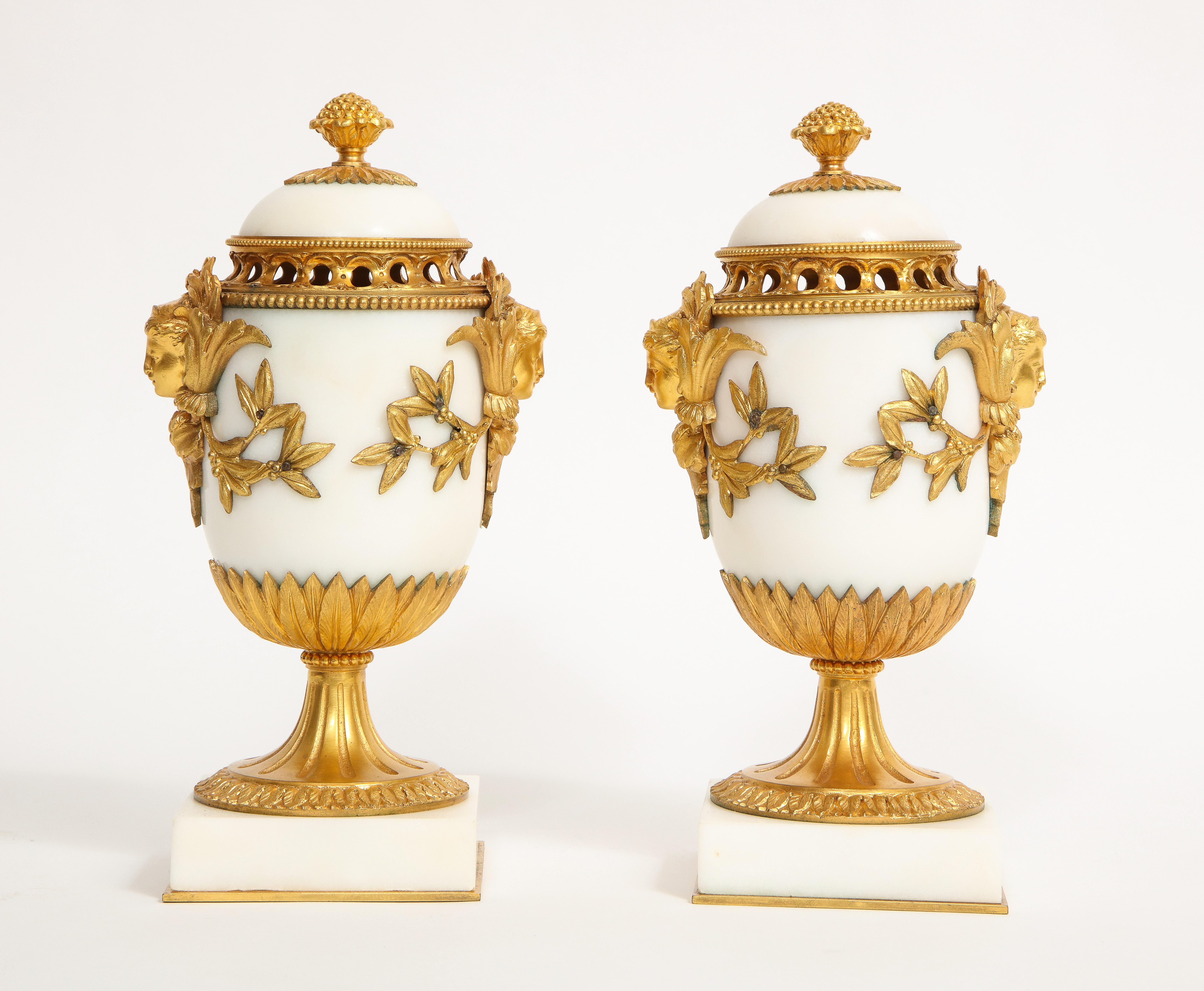 Ein prächtiges Paar französischer Potpourris im Louis-XVI-Stil aus Dore-Bronze, die Henry Dasson zugeschrieben werden. Jedes Stück besteht aus weißem Carrara-Marmor von höchster Qualität und feinsten gegossenen, handziselierten und handgemeißelten