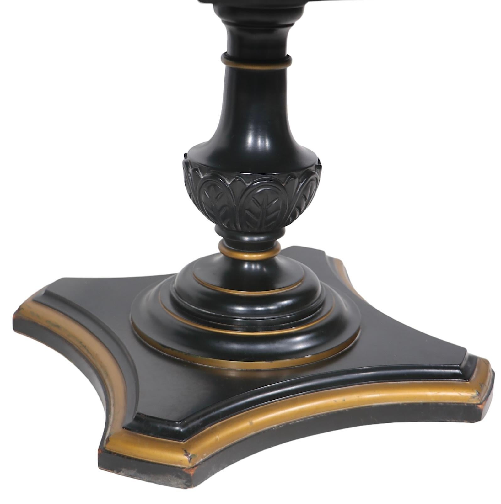 Pair of neoclassic, hollywood regency style end tables, having nice thick marble tops, which rest on hand carved wood pedestal bases in black paint finish with gold trim. The tables function as either end, side or lamp  tables. Both are in very