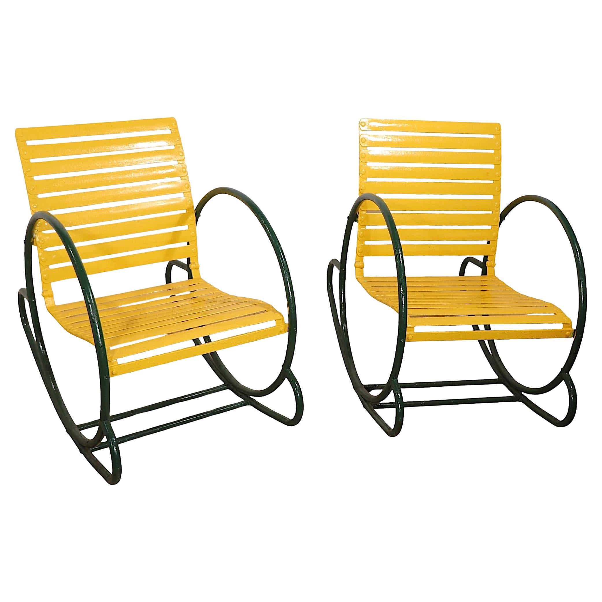 Chic pair of Art Deco hoop form rocking chairs, constructed of tubular metal continuous circular arms, rockers, and flat bars seats and backs. Made by The Cincinnati Artistic Wrought  Iron Works Company, circa 1930's.  The chairs are in very good