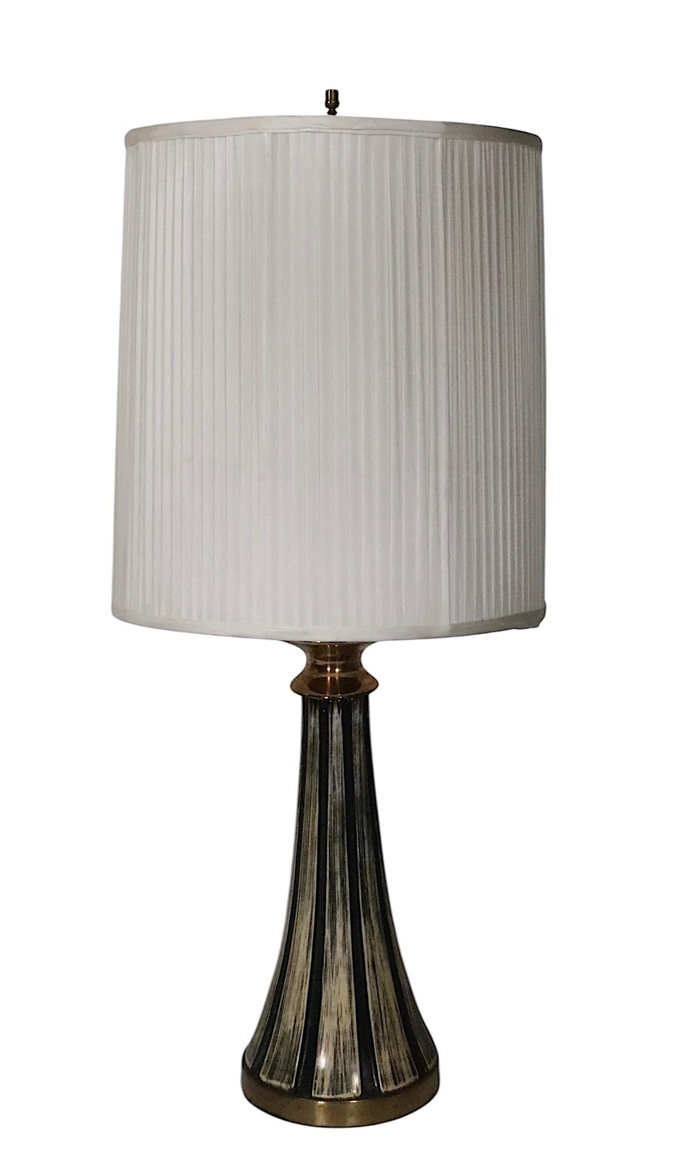 Chic pair of Mid Century Brutalist school table lamps, executed in ceramic, with black, off white , brown and gold toned glaze. Both lamps are in very good,m original, clean and working condition, showing only light cosmetic wear, normal and