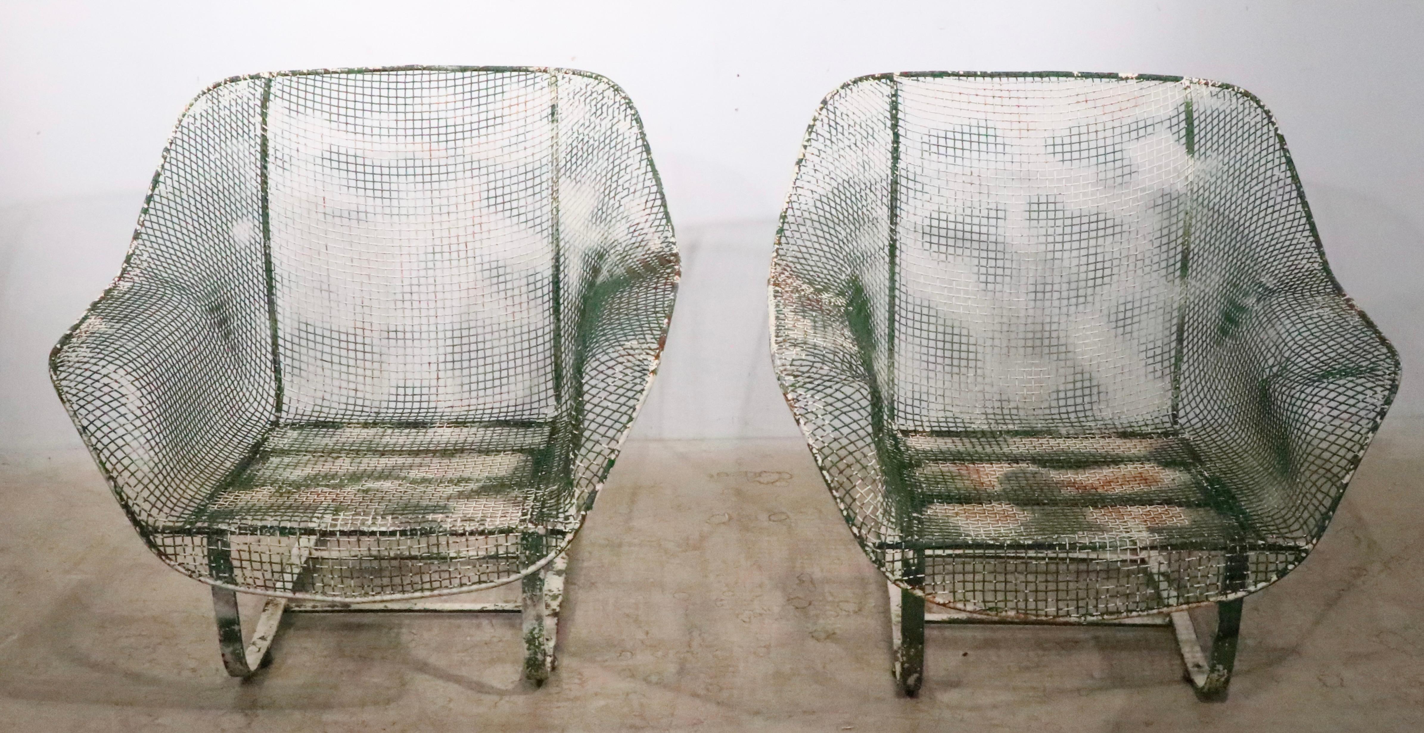 Rare pair of Woodard  Sculptura low lounge chairs, having cantilevered bases and woven metal mesh seats. Both chairs are structurally sound and sturdy, both show significant  to the paint finish, please see images. Usable as is, or we offer custom