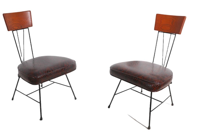 Pair of architectural mid century side chairs by noted designer Richard McCarthy for Selrite Furniture.
The chairs has unusual and chic faux reptile upholstery, wrought iron frame, and solid oak back, headrest.
Priced and offered as a pair.