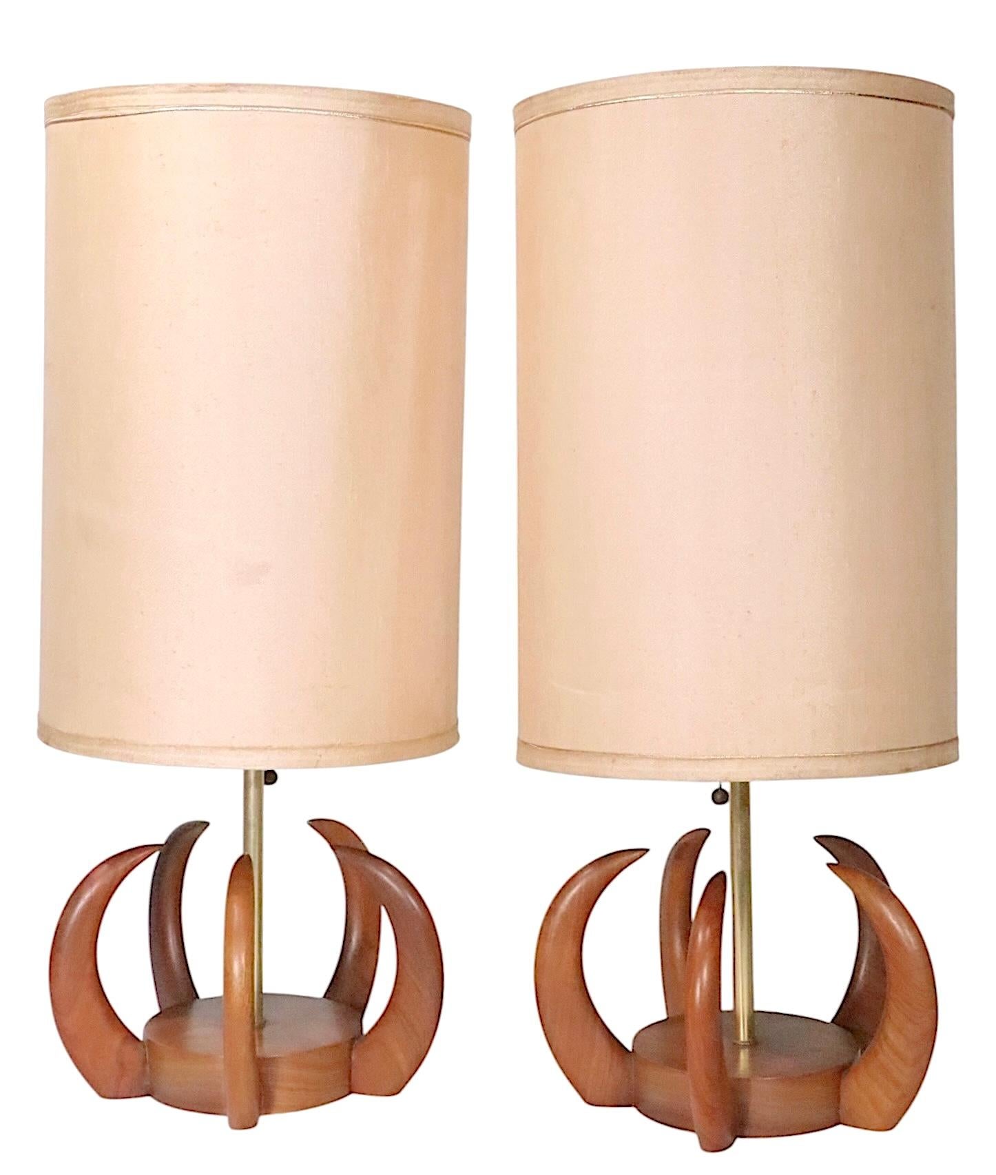 Pr. Organic Mid Century Modern style table lamps executed in solid walnut with curved tusk formed shapes which surround the disk form base. The lamps are reminiscent of Modeline, Pearsall and Jacobs, unsigned.
Both are in very good, original,
