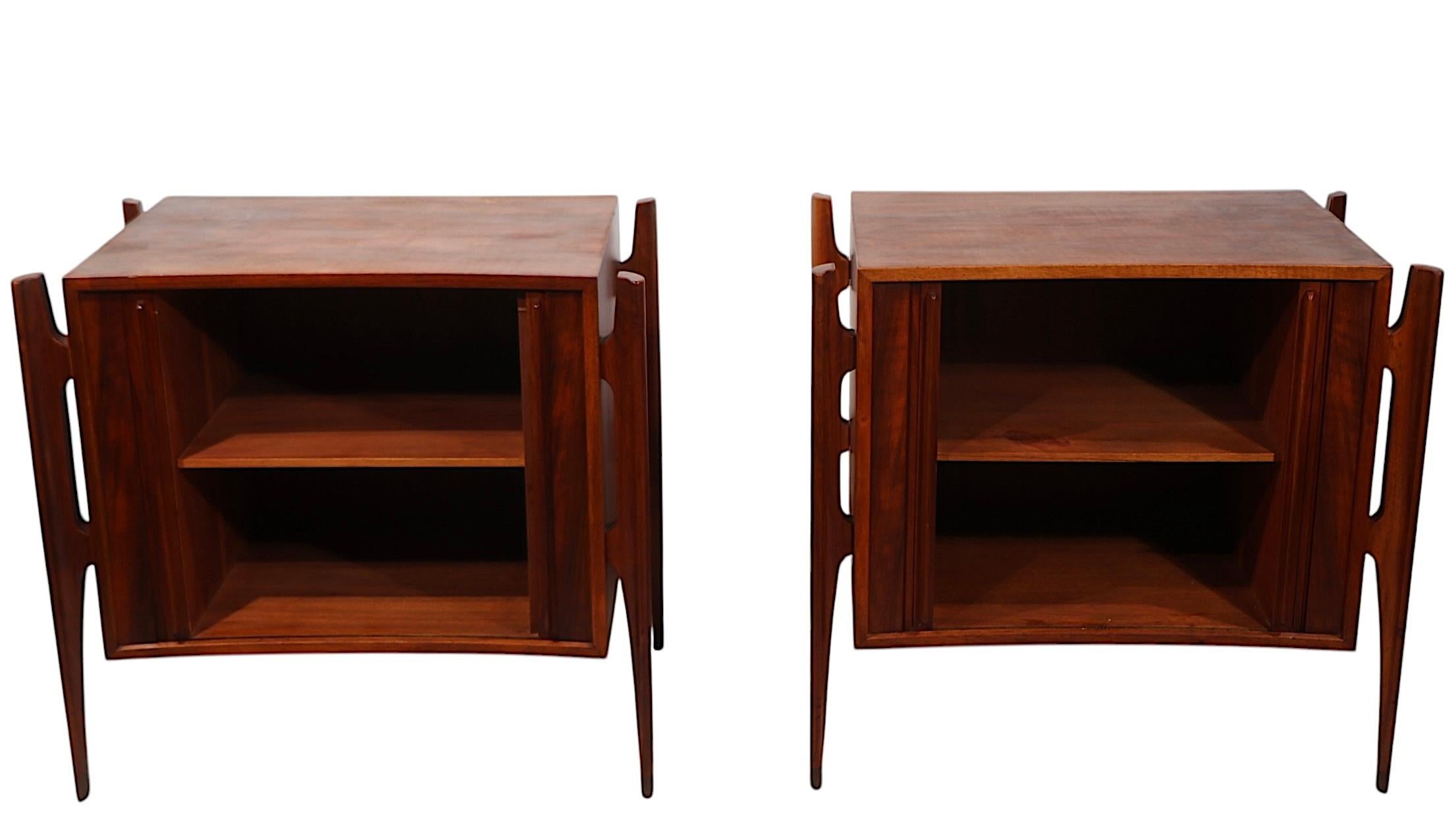 Exceptional pair of Mid Century night tables, designed by William Hinn for Urban Furniture, made in Sweden circa 1950's. The cabinets feature an architectural frame with exposed organically styled  sculptural legs, which support the sliding tambour