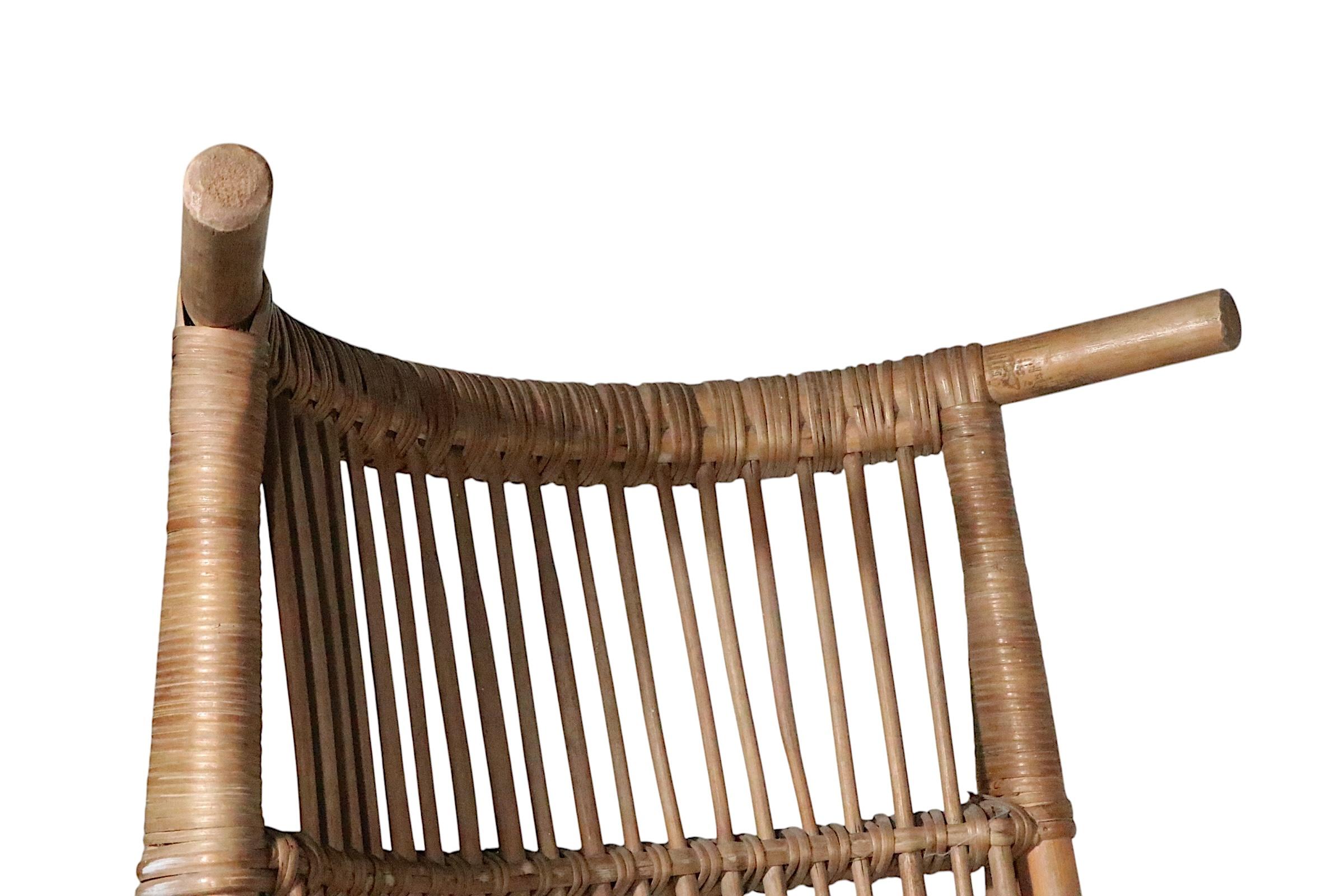 Stunning pair of high back bamboo lounge chairs, probably made in France circa 1950/60's, in the style of Audoux Mannet, unsigned. The chairs feature low slung seats, with a exaggerated and dramatic tall back rest. Both chairs are in very good,