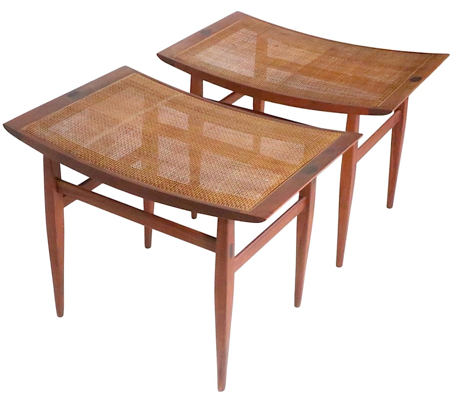 Sophisticated pair of mid century Drexel Declaration benches, designed by Kipp Stewart and Stewart MacDougall, circa 1950/60's. 
 The stools feature curved caned tops, mounted on elegant tapering legs. Executed in solid walnut, with oval parquetry