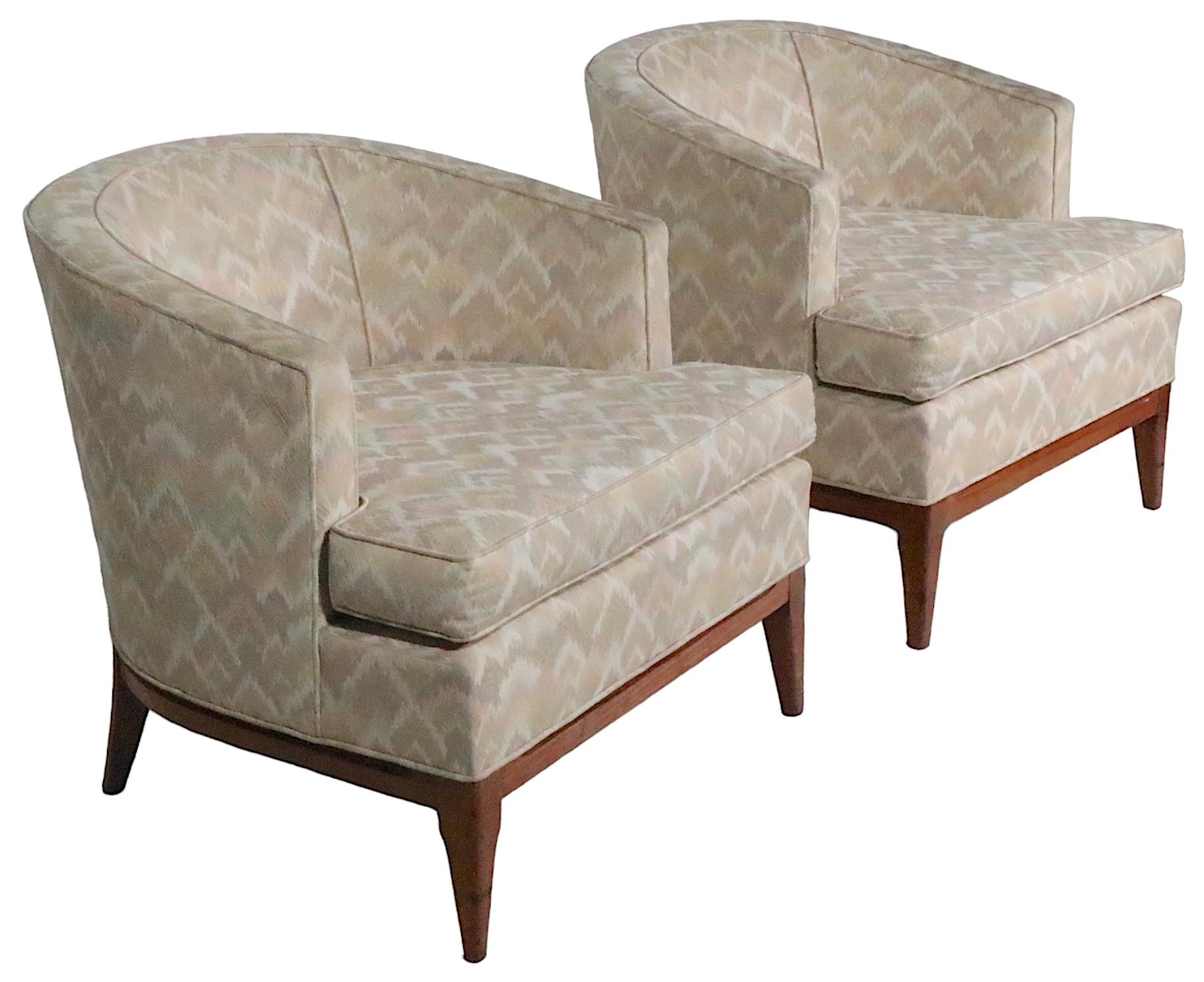 Chic pair of midcentury, Hollywood Regency style tub, lounge chairs, in the style of Robsjohn Gibbings. Both chairs are in very good, original, clean and ready to use condition, showing only light cosmetic wear, normal and consistent with age. 
