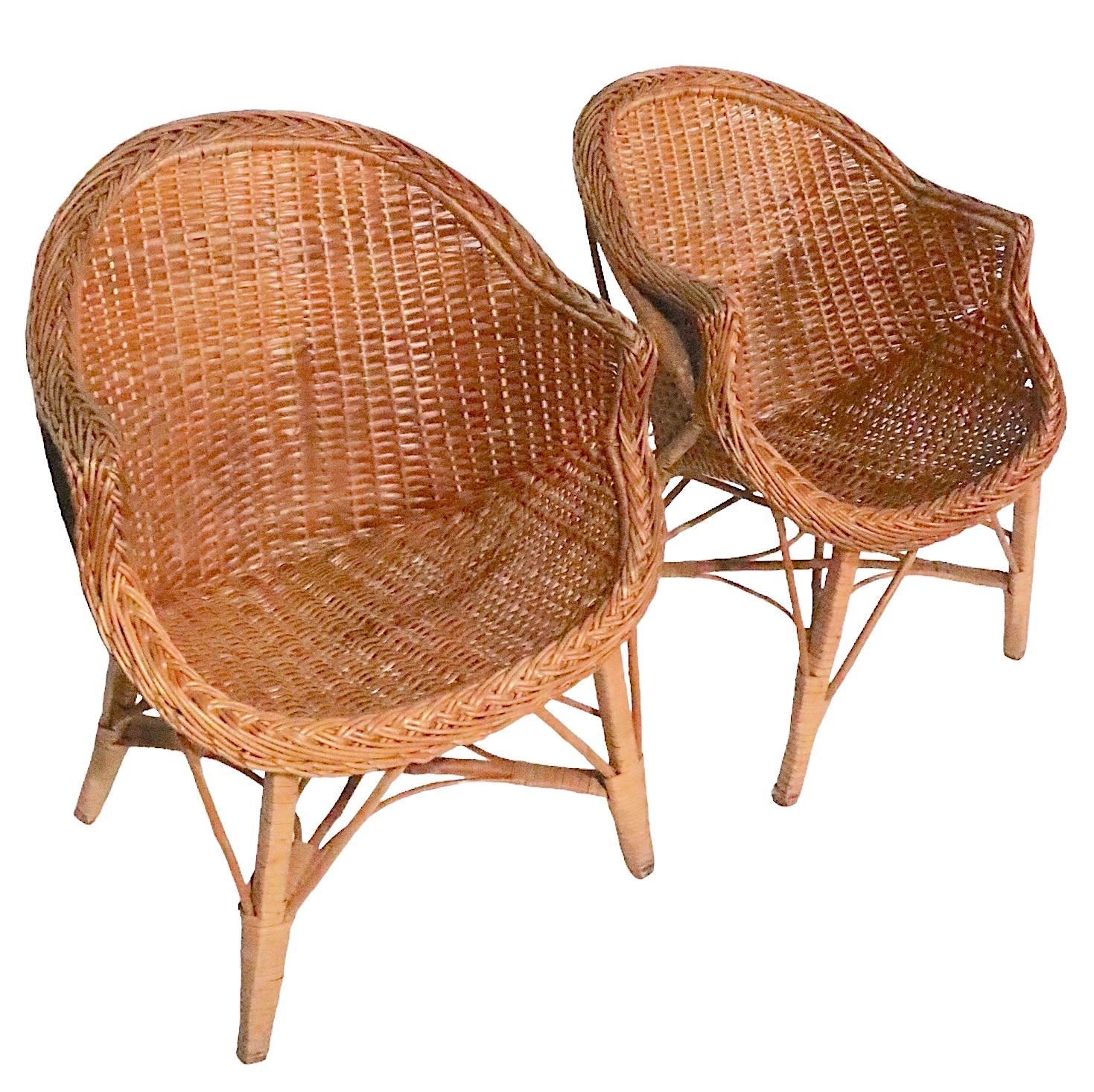 Voguish and chic pair of  mid century woven wicker tub chairs, executed in the style of Franco Albini. The chair are in very good, clean and ready tones condition, showing only light cosmetic wear, normal and consistent with age, offered and priced