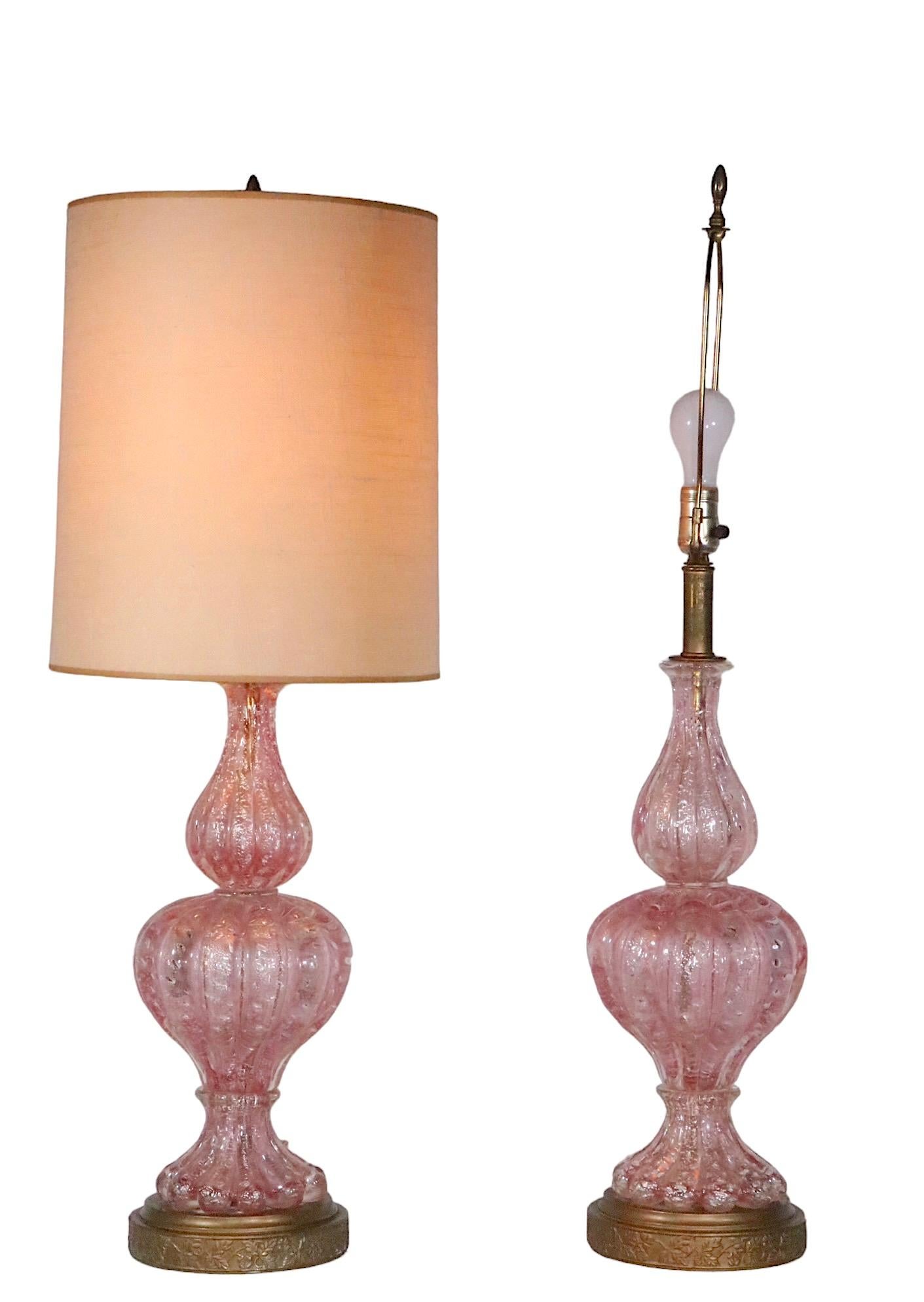 Spectacular pair of Art Glass table lamps, made in Murano, Italy, circa 1950’s, attributed to Barovier.
 The lamps feature internal  controlled bubbles, encased in clear and pink glass with silver foil fragments. 
Voguish, sophisticated lamps, in