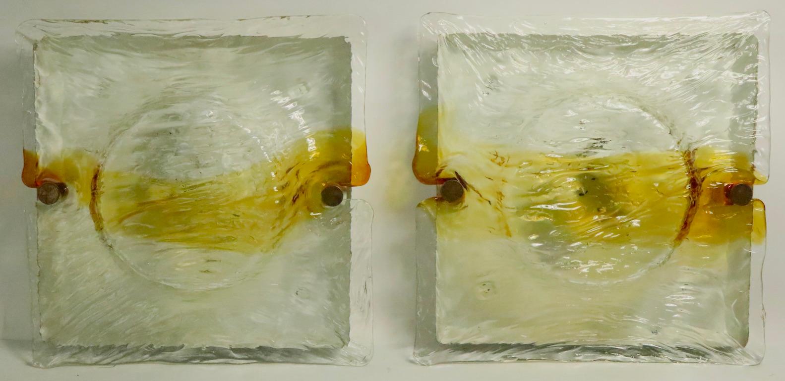 Spectaculaire paire d'appliques de Murano avec des abat-jour en verre formé et texturé, montés sur des plaques de métal. Chaque plaque arrière comporte deux douilles qui acceptent des ampoules à vis de taille standard, toutes deux marquées Made in