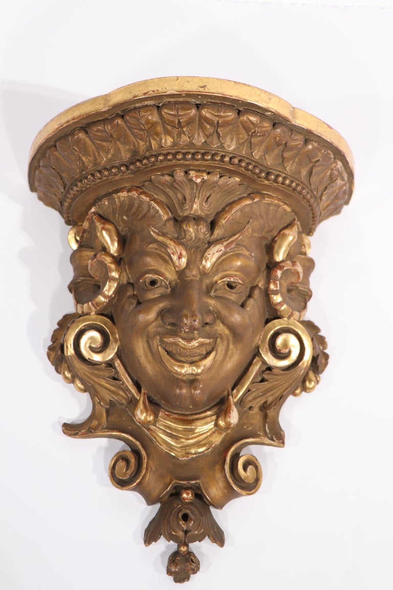 Stunning pair of gilt wood sconces of carved wood with mythological horned man beast motif. Both pieces are in very good original condition, each shows minor loss to edge trim, please see images. One is somewhat larger than the other - see