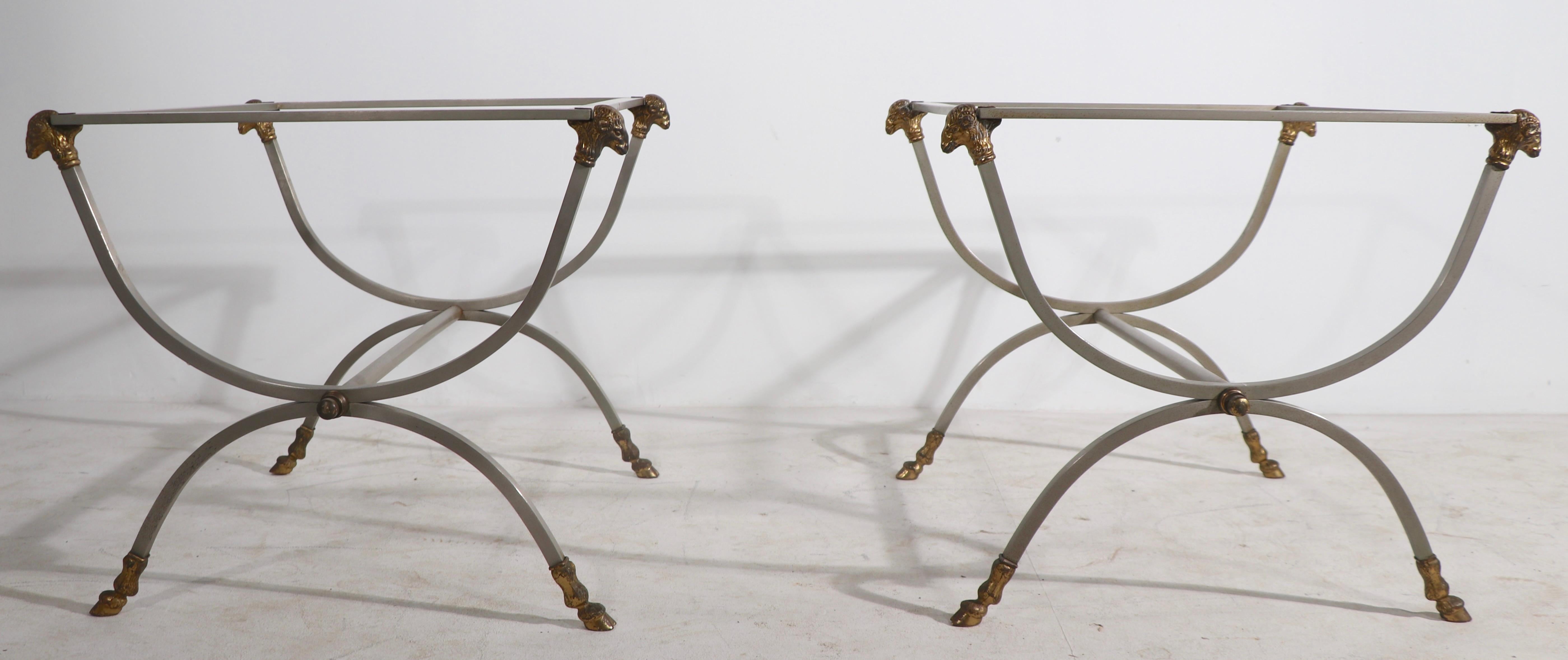 Chic pair of steel and brass end, or side, tables having square stock steel frames with cast brass goat heads, and hoofs as ornament. The tables are structurally sound and sturdy, they show minor surface wear, most of which will polish out, and they
