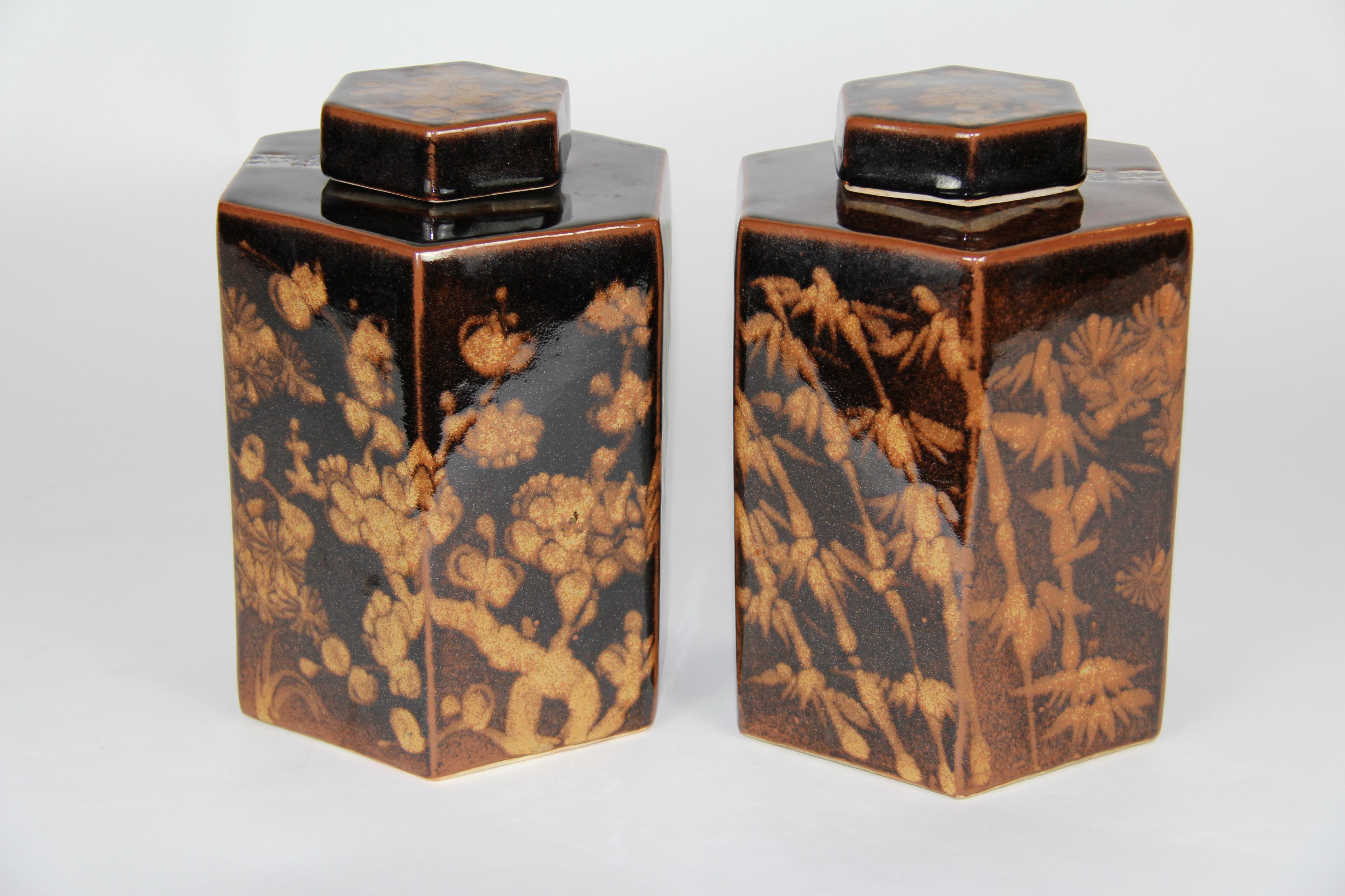 A beautiful pair of antique Chinese hexagonal form hand painted Porcelain tea caddies with floral and bamboo motifs. Each is beautifully hand painted on porcelain with a rich brown ground and golden tan flowers. They are of hexagonal form with