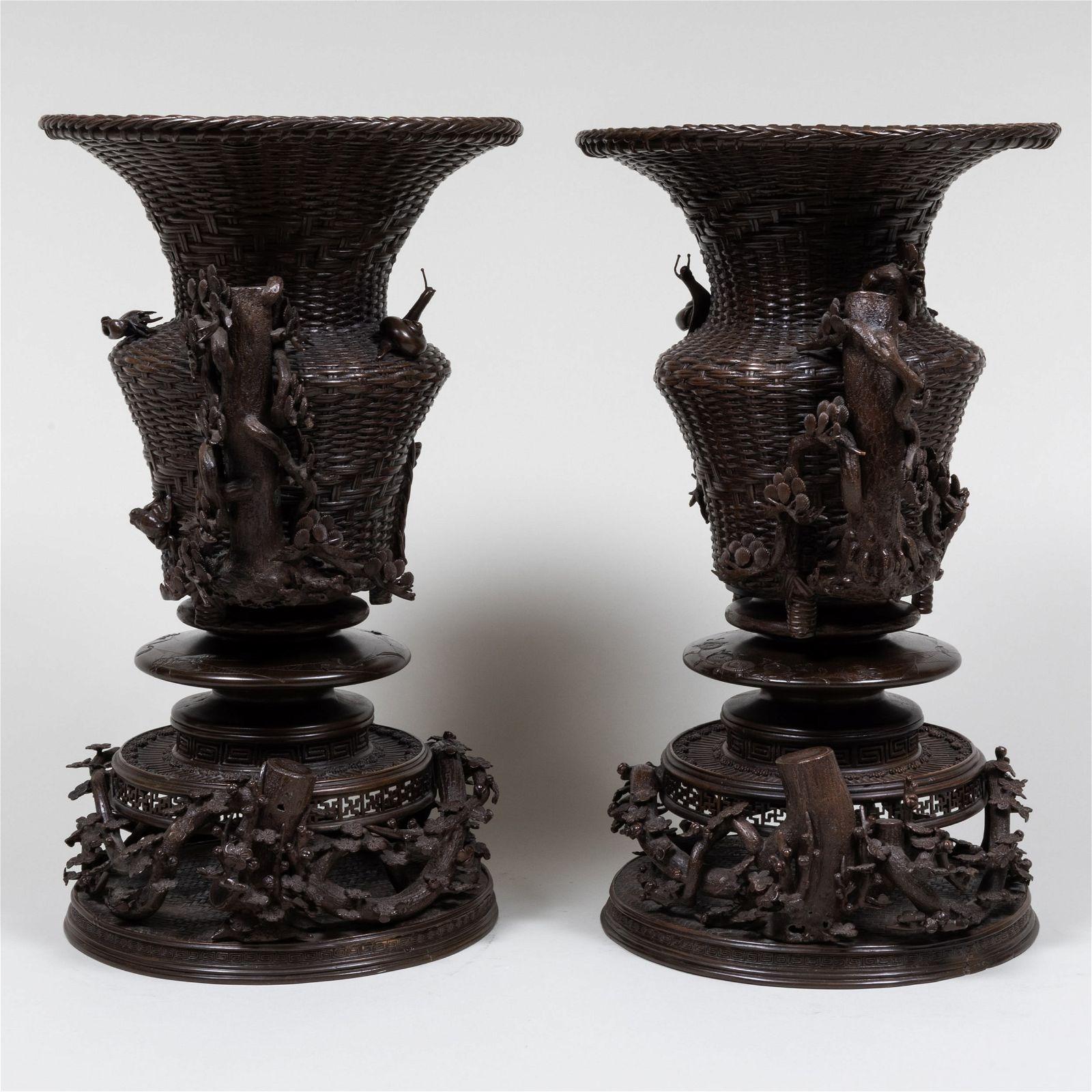 Paar von feinster Qualität  große, antike Bronzevasen aus der Meiji-Periode in Form eines geflochtenen Korbes mit Griffen in Form eines Baumzweiges, verziert mit verschiedenen Motiven wie Insekten, Knospen und Blumen.  Jeder mit zwei Abschnitten. 