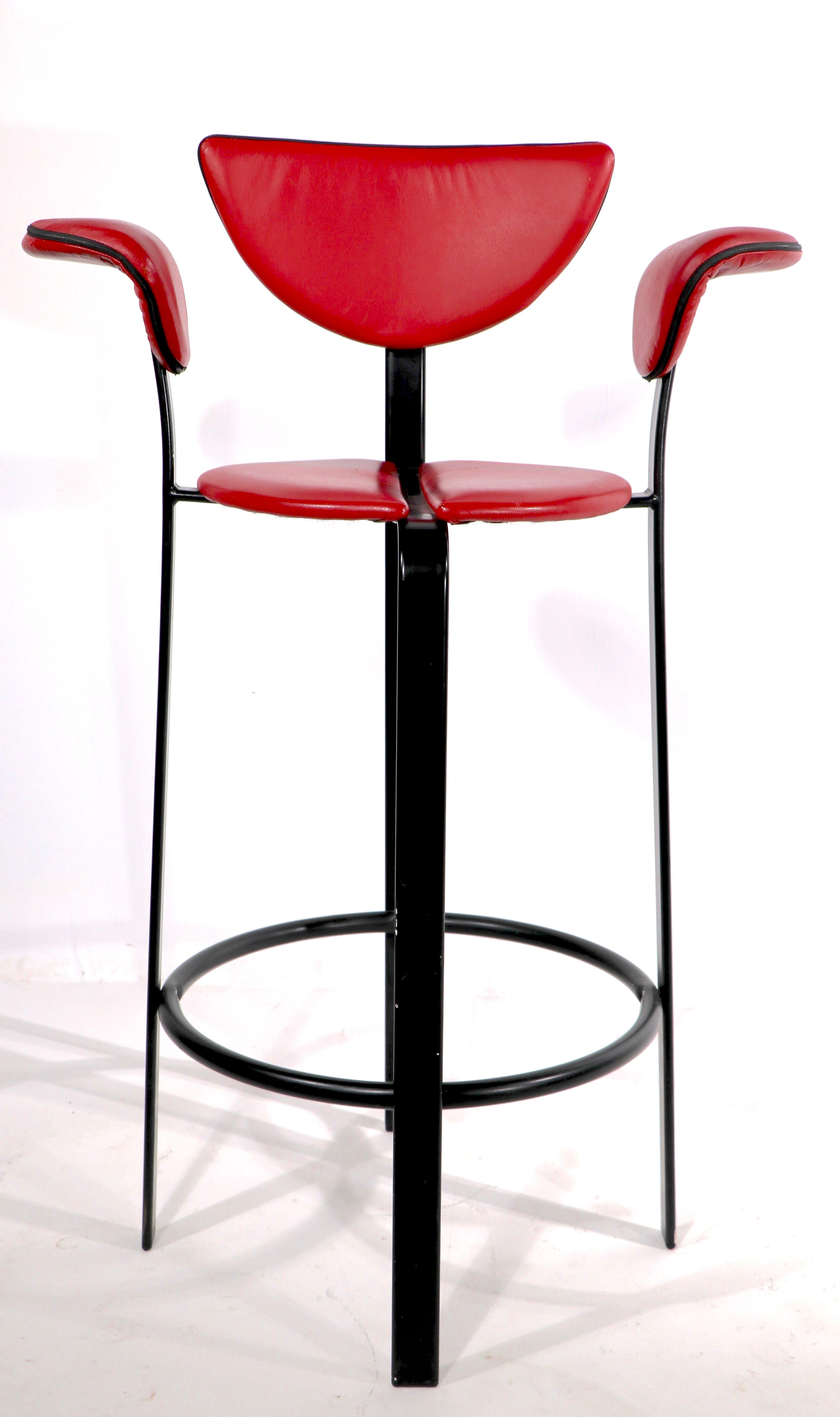 Chic postmodern tall bar stools marked BSK, made in Denmark. The stools feature red leather with black piping seats, backs, and arm rests on metal frames in black finish. Both are in very good, original condition, showing only light cosmetic wear,