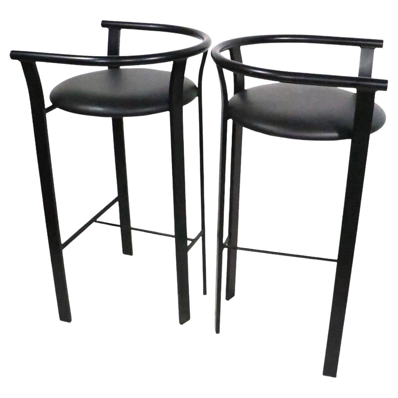 Nice clean pair of Post Modern counter height stools made in Canada, by Amisco, circa 1990-2020. Both are in excellent , original, clean and ready to use condition. Executed in black finished metal and upholstered pad seats, priced and offered as a