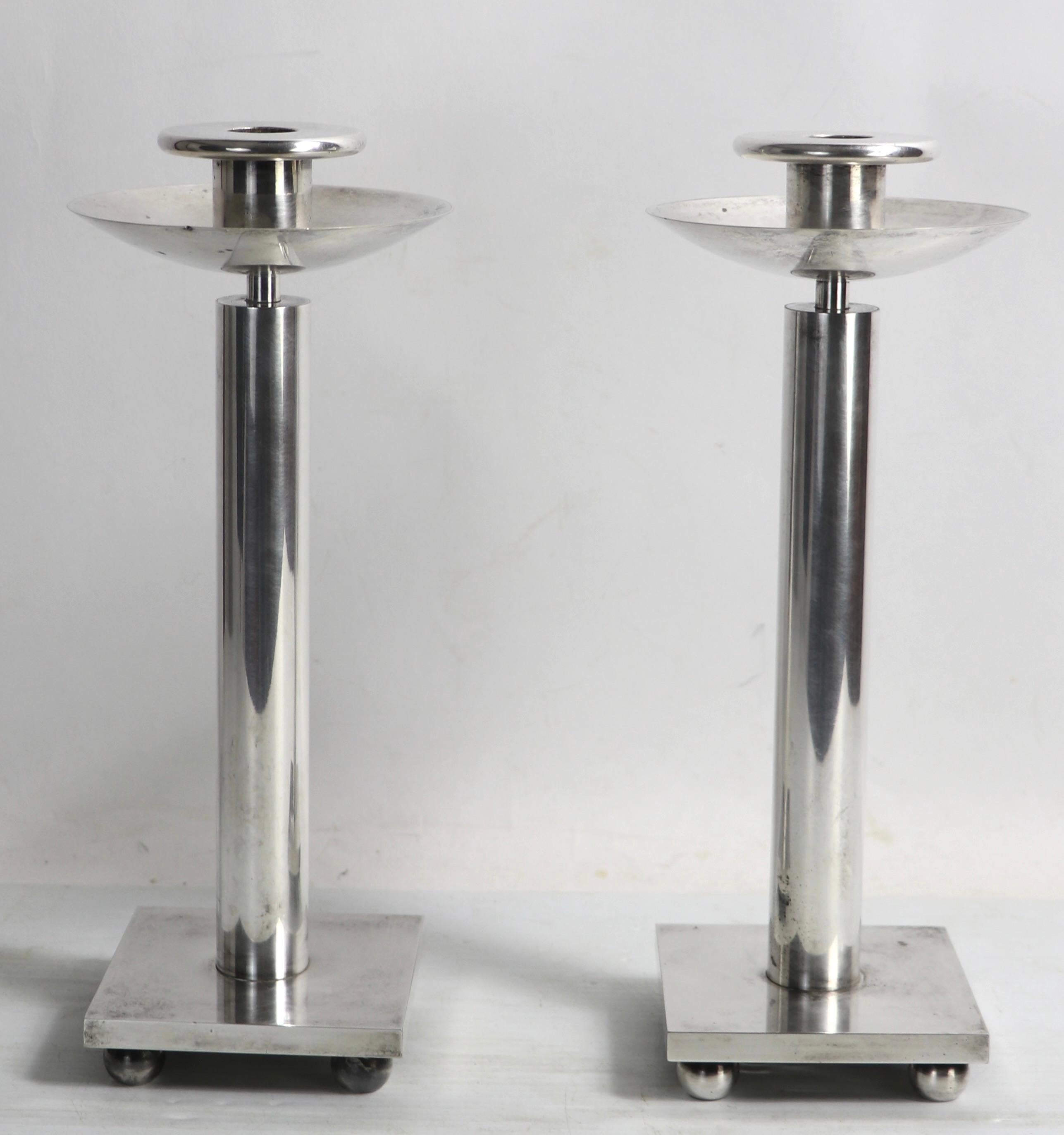 Incredible pair of post modern silver plate candlesticks, by Richard Meier for Swid Powell. Very hard to find, especially in pairs, this impressive set will complete a table setting, mantle or any interior you choose to place them in. The restrained