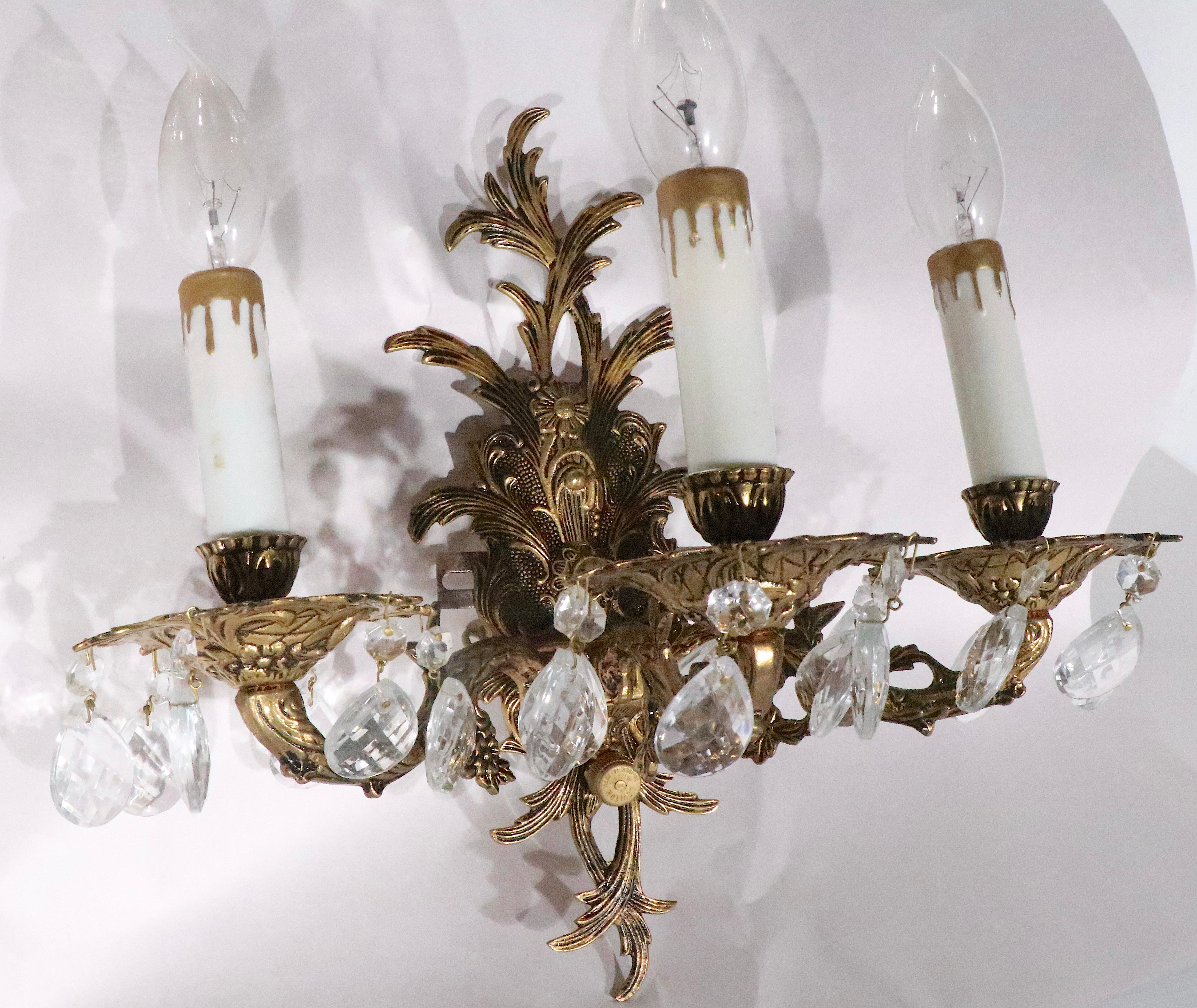 Pair of Rococo Revival cast brass sconces, each having three arms, each arm having a candle sleeve socket. Made in Spain, circa 1950- 1970's. Both sconces are in excellent, clean, original, working condition, offered and priced as a pair.  