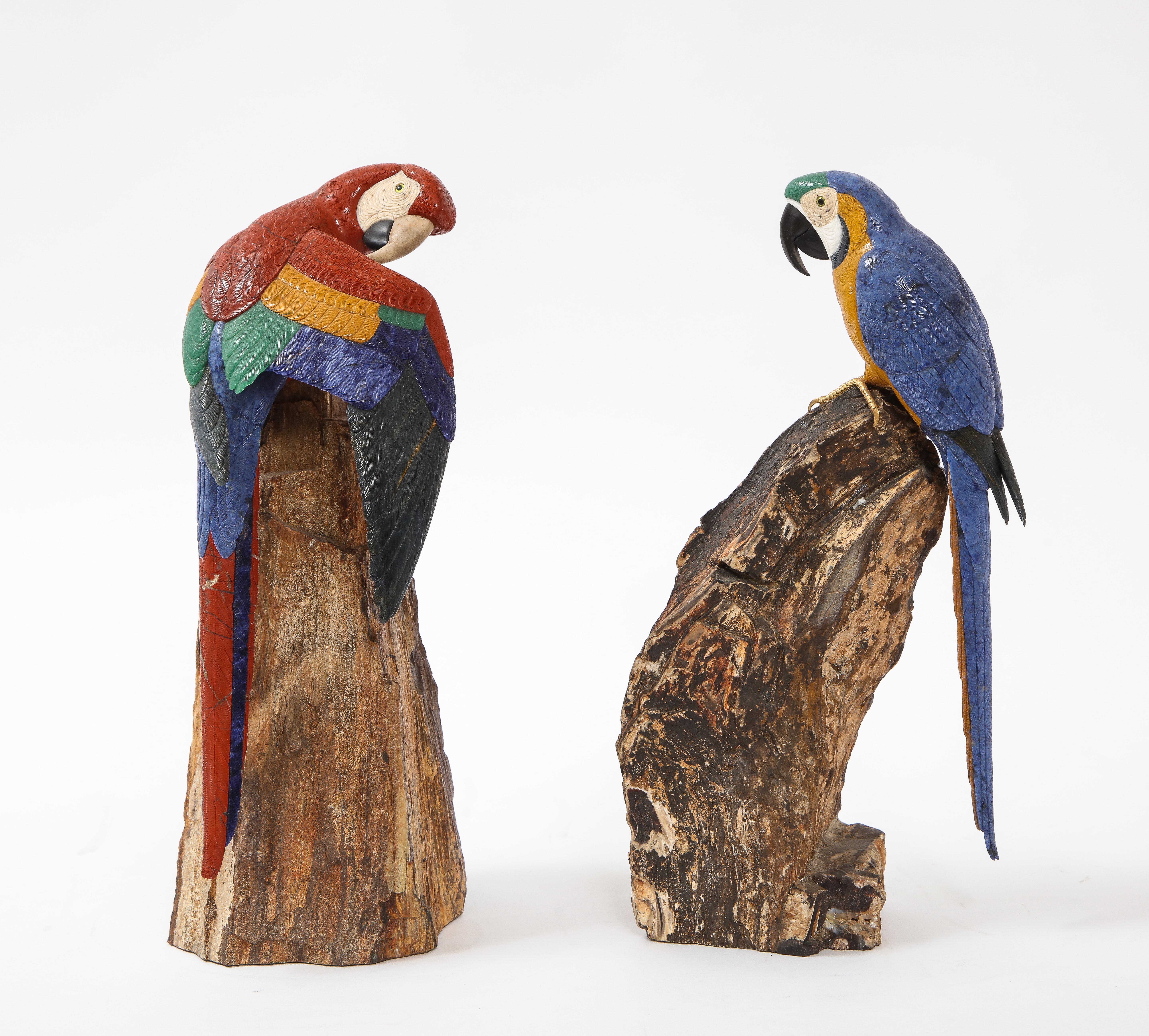 A fantastic pair of multi-semi precious stone and gold mounted Models of Scarlet Macaw Parrots, Attributed to Peter Müller, Swiss. This regal pair of Scarlet Macaws are each perched in royal splendor upon a pair of exceptional specimens of petrified