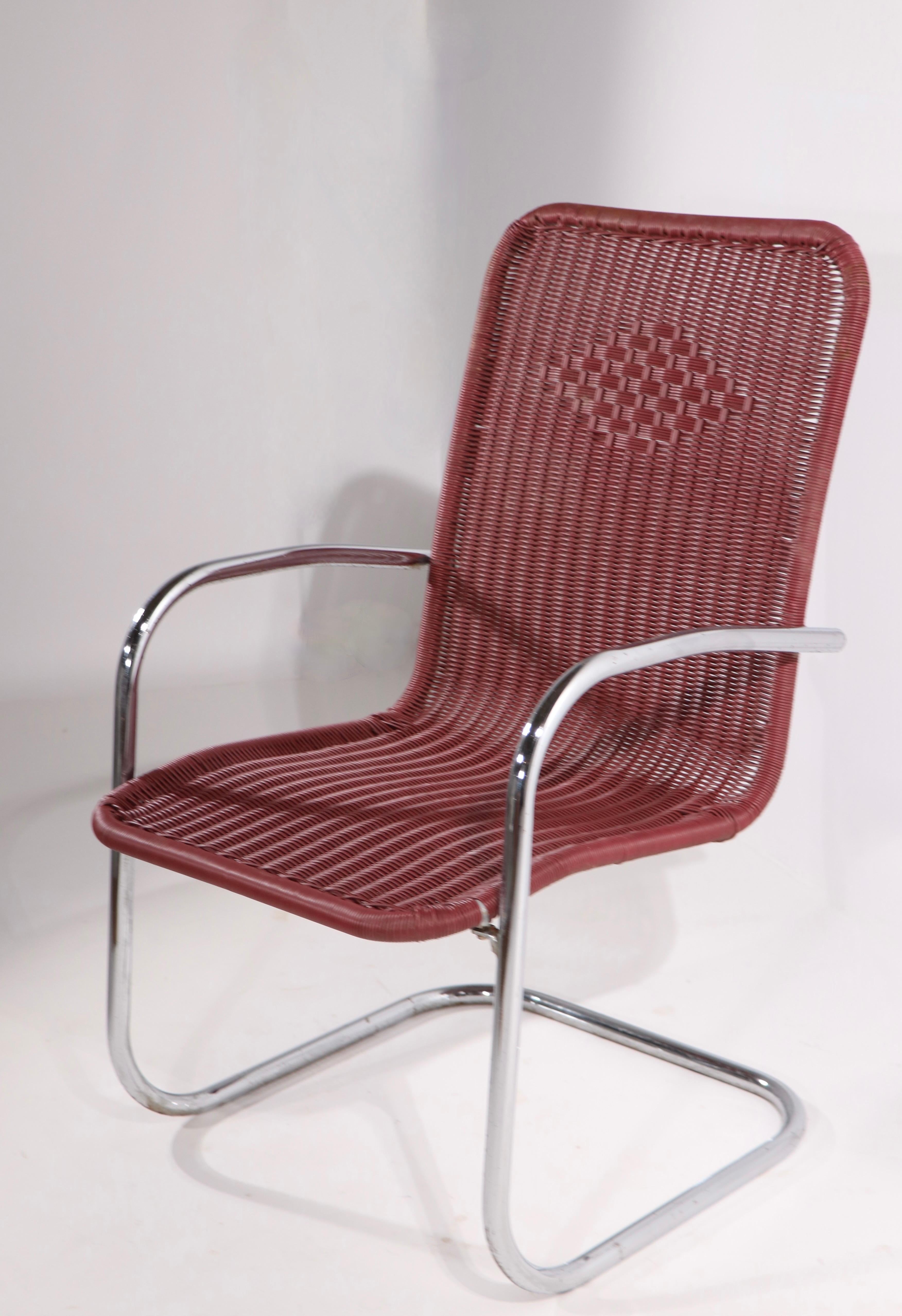 Pair of cantilevered lounge chairs having tubular chrome frames and continuous plastic wicker style woven seats and backs. Very chic design, manufacture attributed to Lloyd Loom, unsigned. Both show some wear, blemishing, and loss to chrome plating,