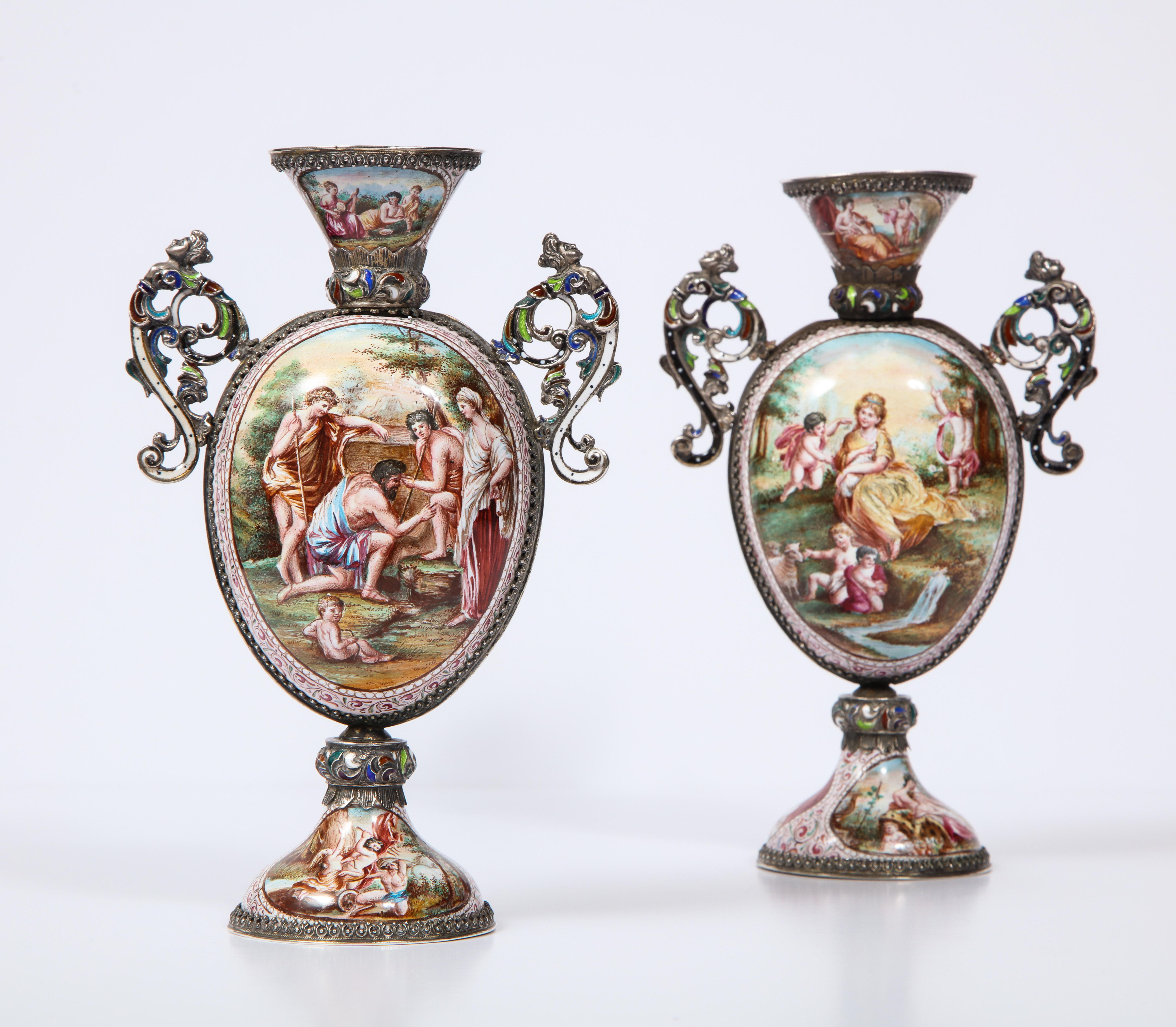 A beautifully pair of Viennese poly-chrome enamel on silver vases with mythological scenes and signed hallmarks: HB. There are a total of twelve panels, six on each vase, and each panel is exquisitely hand painted in multicolored poly-chrome enamel