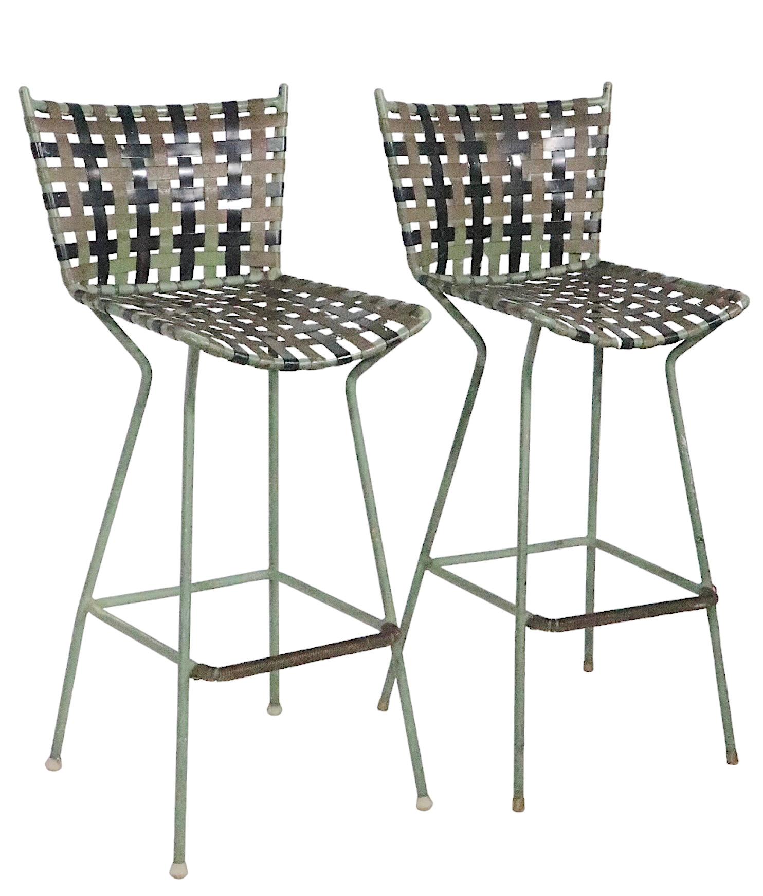 Pair of Mid Century bar stools having aluminum frames with woven plastic straps. The stools are structurally sound and sturdy, they both show significant wear, and are being offered as is. I suspect these were once in an artists studio, given their