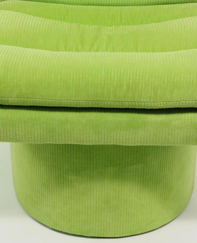 Wonderful pair of 1970s swivel chairs in original vibrant green corduroy fabric. The chairs feature a cylindrical pedestal base (16 in diameter) which support the upholstered armless seat. The seats swivel and return to the forward facing position