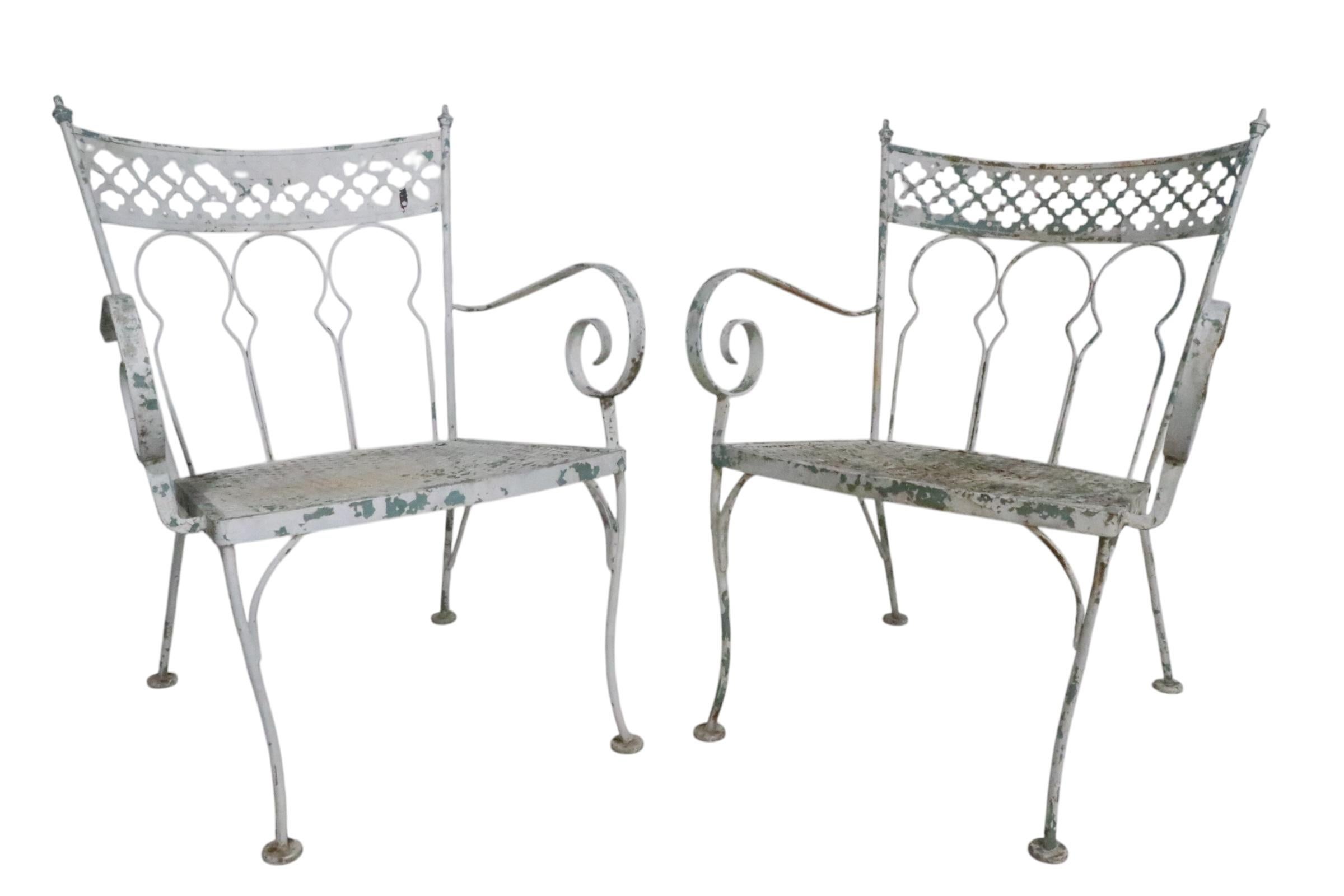 Vistosa pareja de sillas vintage de jardín, patio y piscina, de Salterini, que forman parte de la codiciada serie Taj Mahal, alrededor de 1950. Las sillas tienen  espectaculares brazos curvilíneos estilizados, respaldos metálicos perforados con el