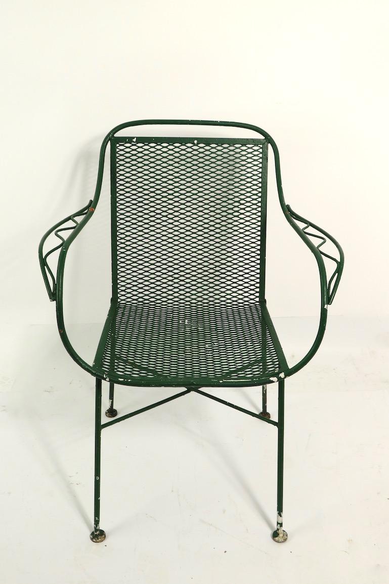 Pair of patio, garden chairs by Salterini. The chairs have a wrought iron frame, with metal mesh seats and backrests. Both chairs are in very good condition, free of structural damage, both are in later, but not new, green paint finish. Offered and