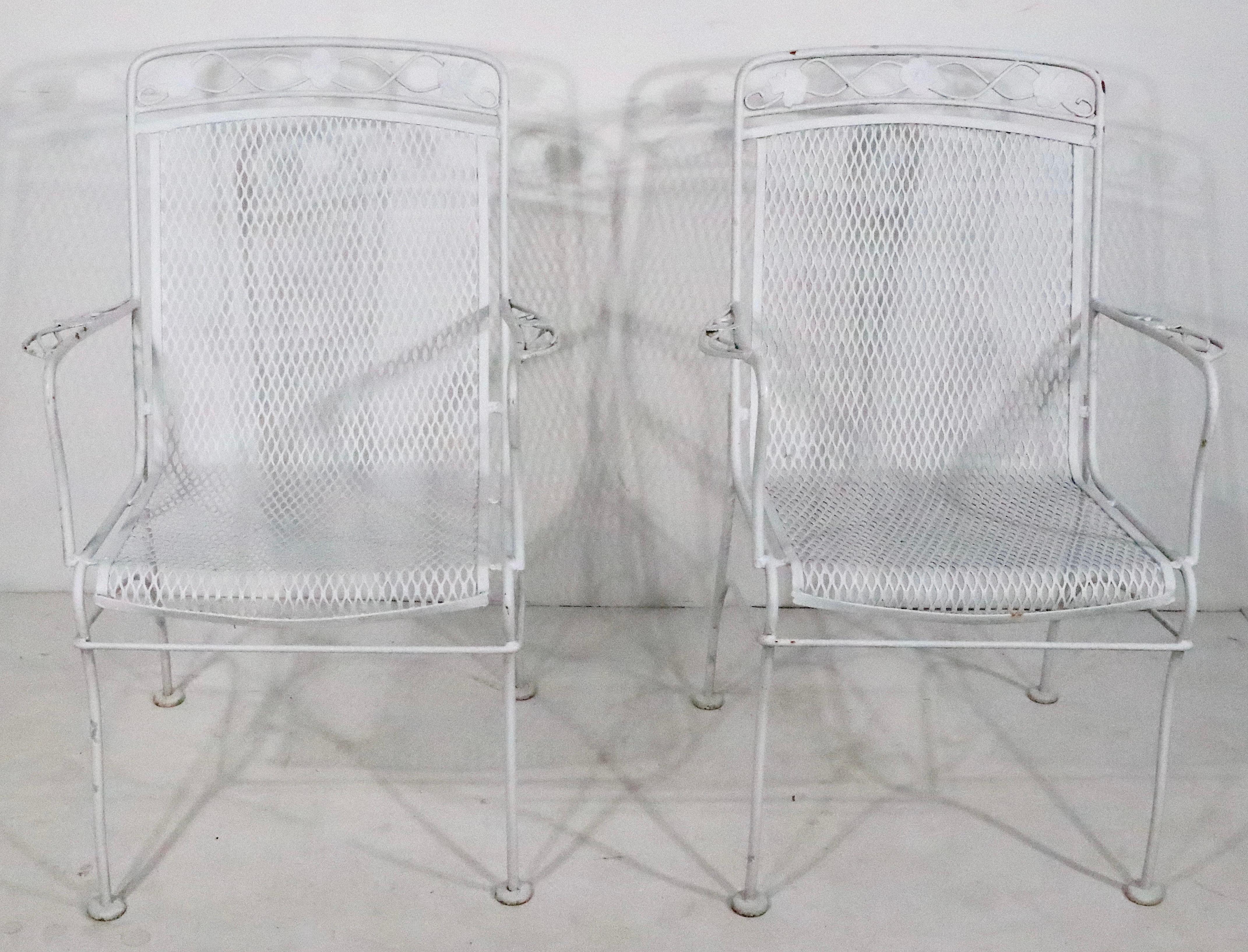 Pr.  vintage high back metal garden, patio, poolside, wrought iron and metal mesh chairs by Woodard Furniture. The chairs feature a continuous back and seat of metal mesh, mounted a wrought iron frame, with decorative metal work foliate. Both are in